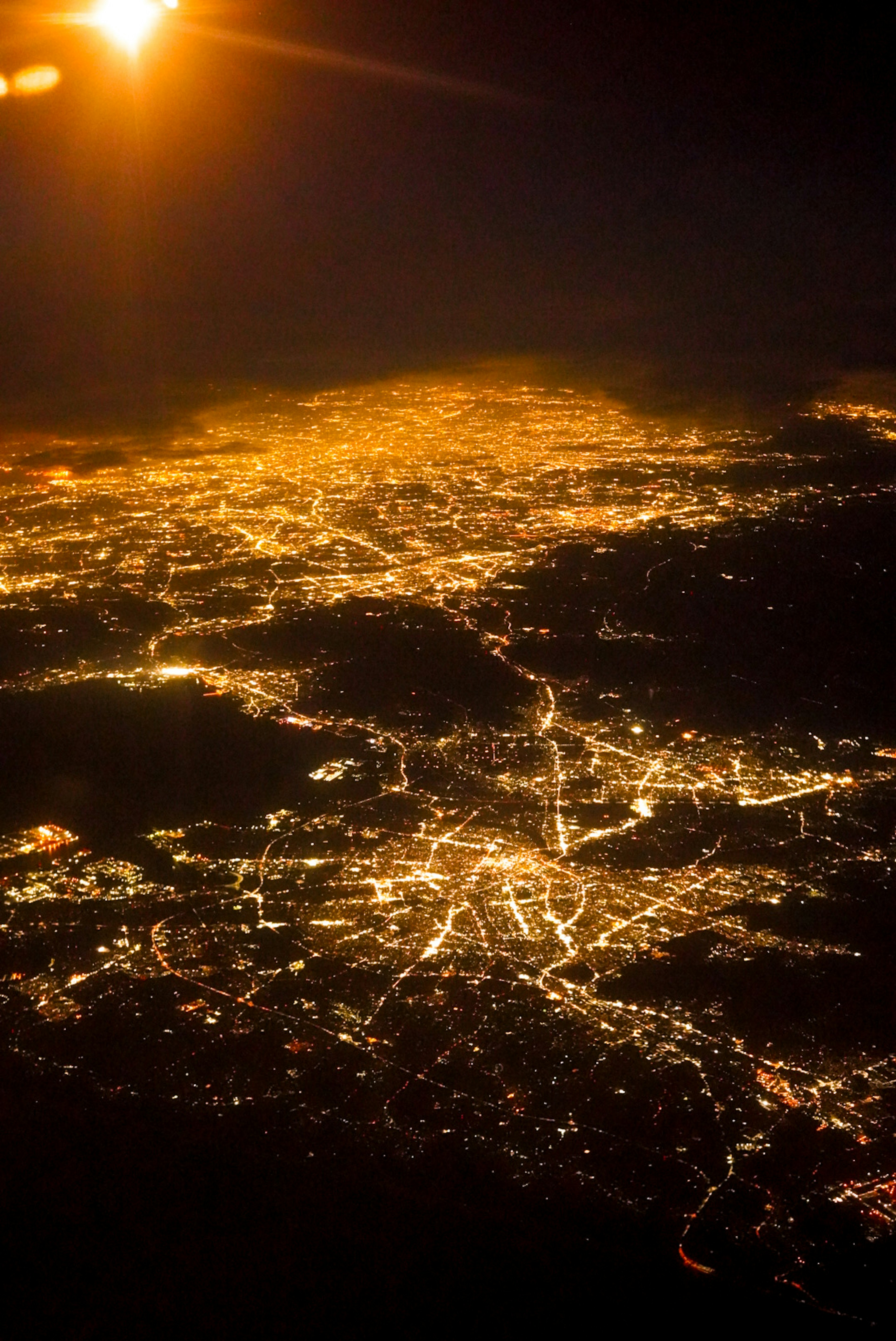 Vista aérea de una ciudad de noche con luces de calles y carreteras iluminadas