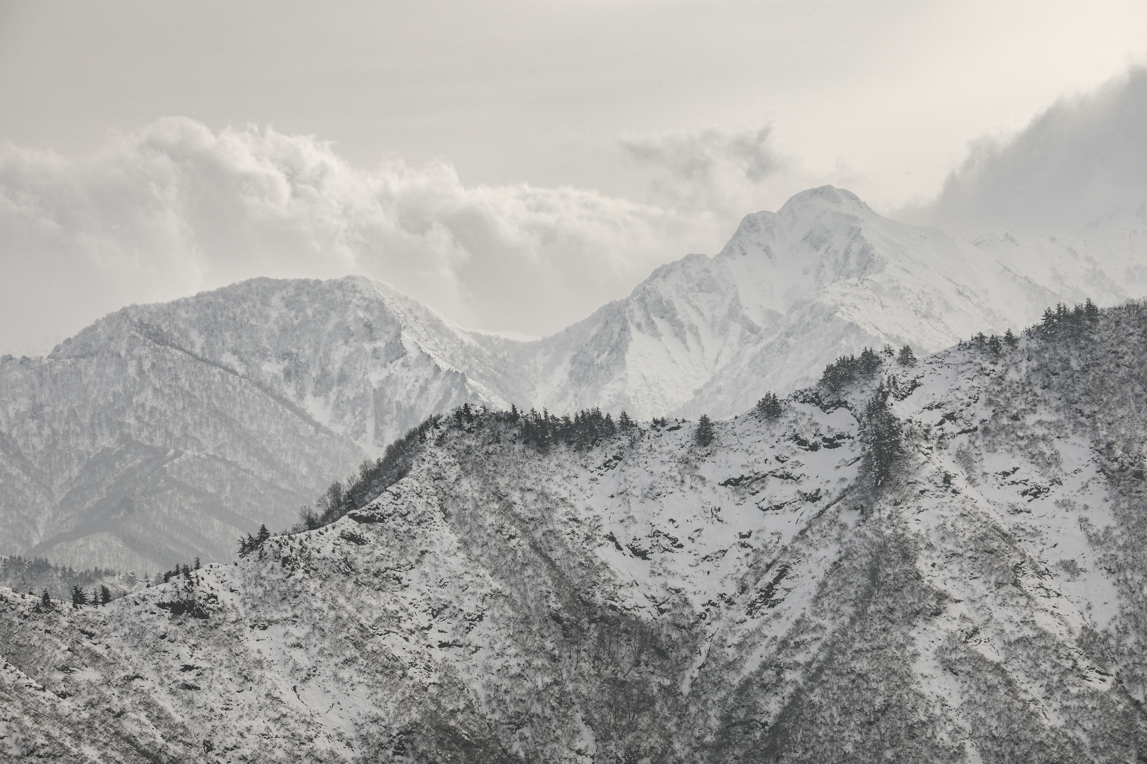 Snow-covered mountains under a cloudy sky