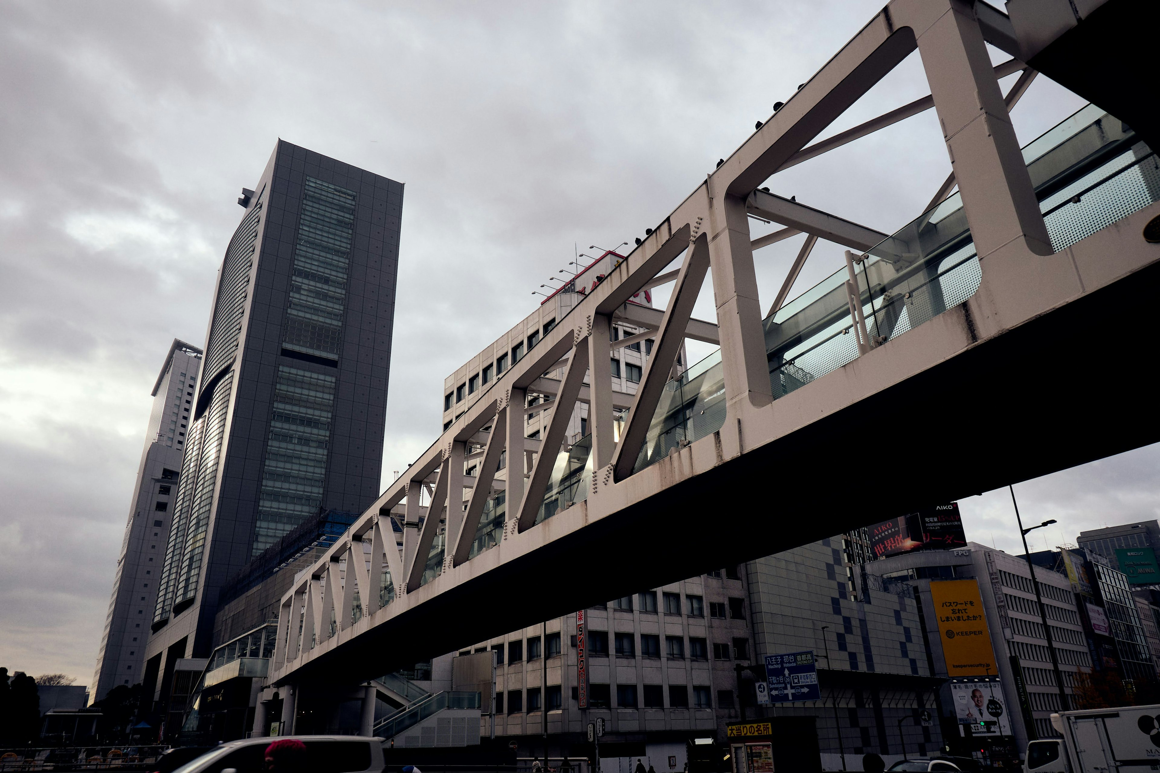 近代的なビルと歩道橋が交差する都市の風景