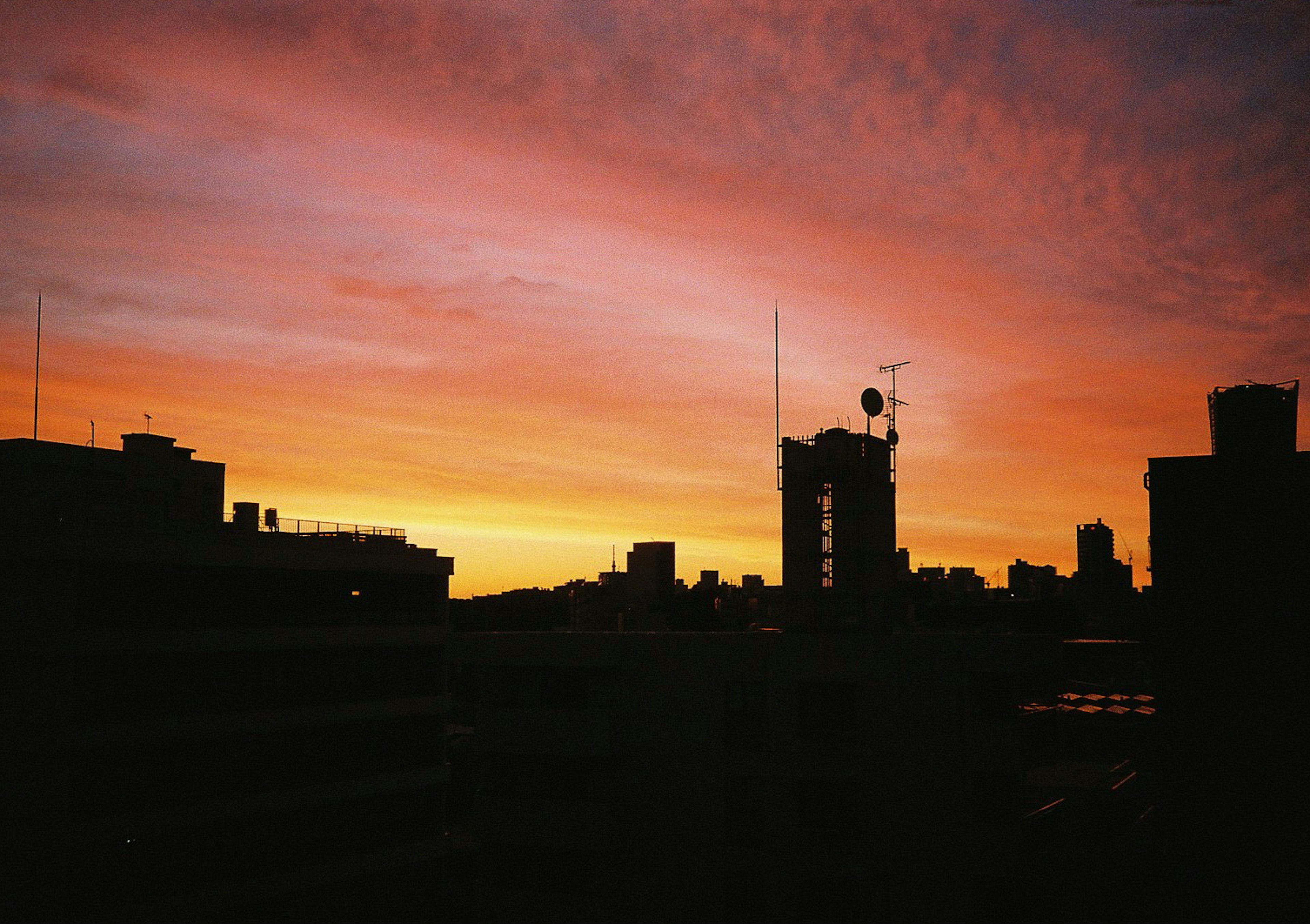 Stadtansicht silhouettiert vor einem lebhaften Sonnenuntergang