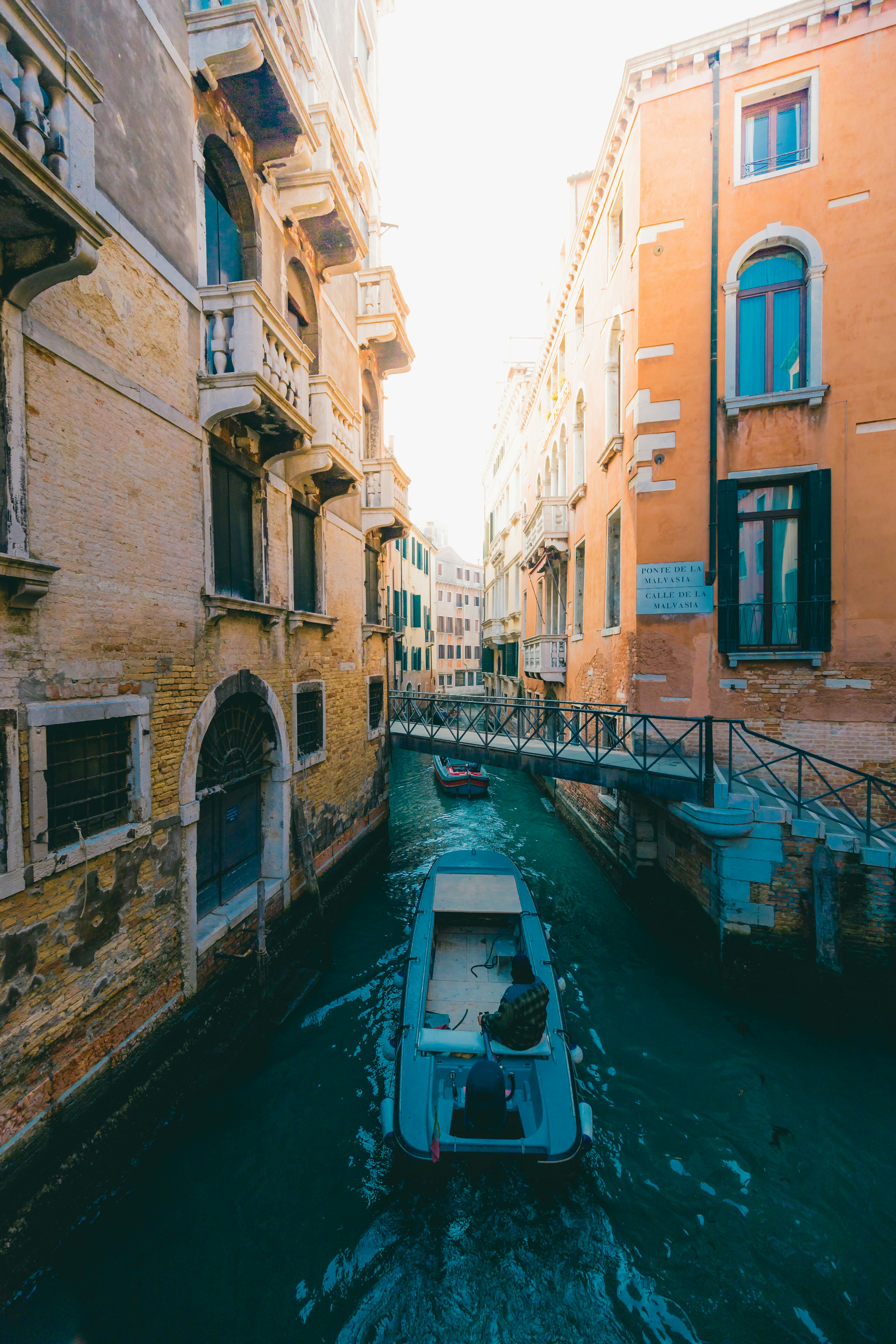 A small boat navigating through a canal surrounded by historic buildings