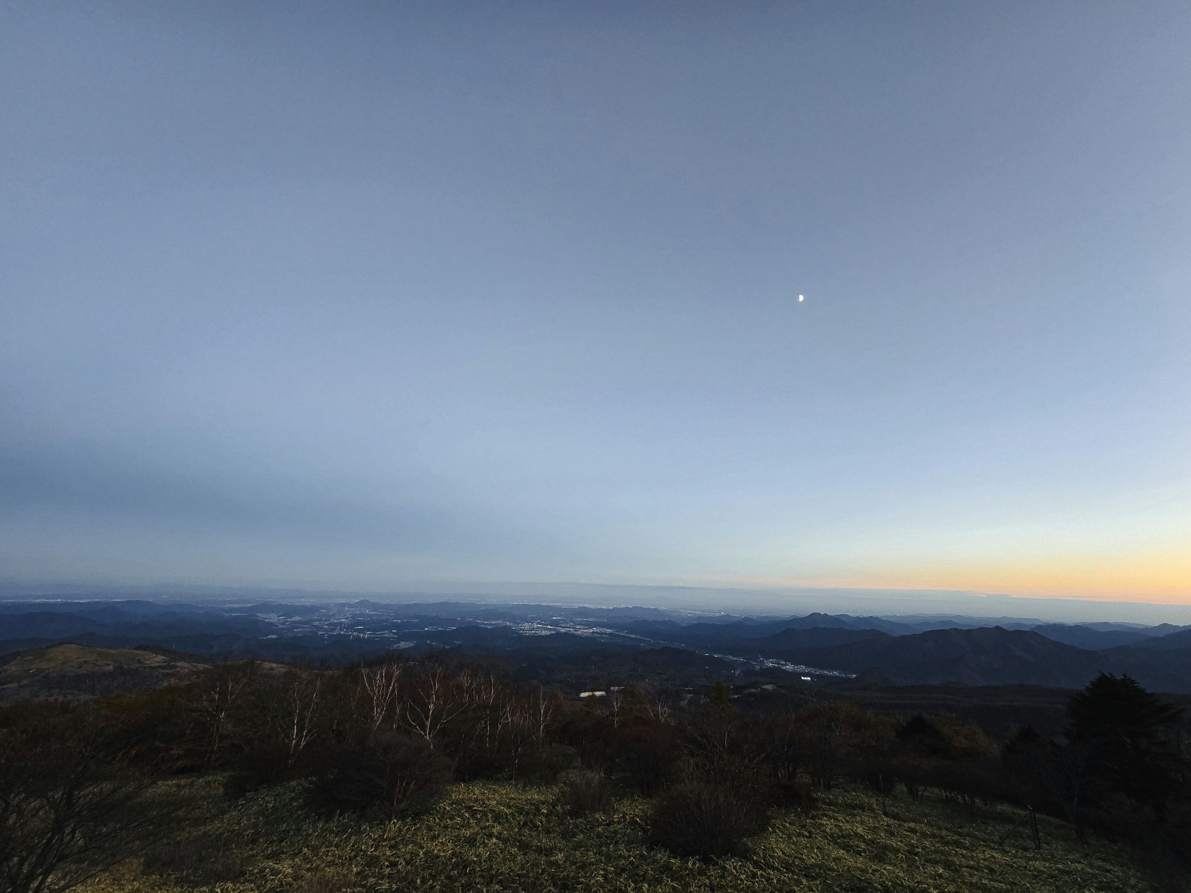 Berglandschaft mit blauem Farbverlauf und Mond in der Dämmerung