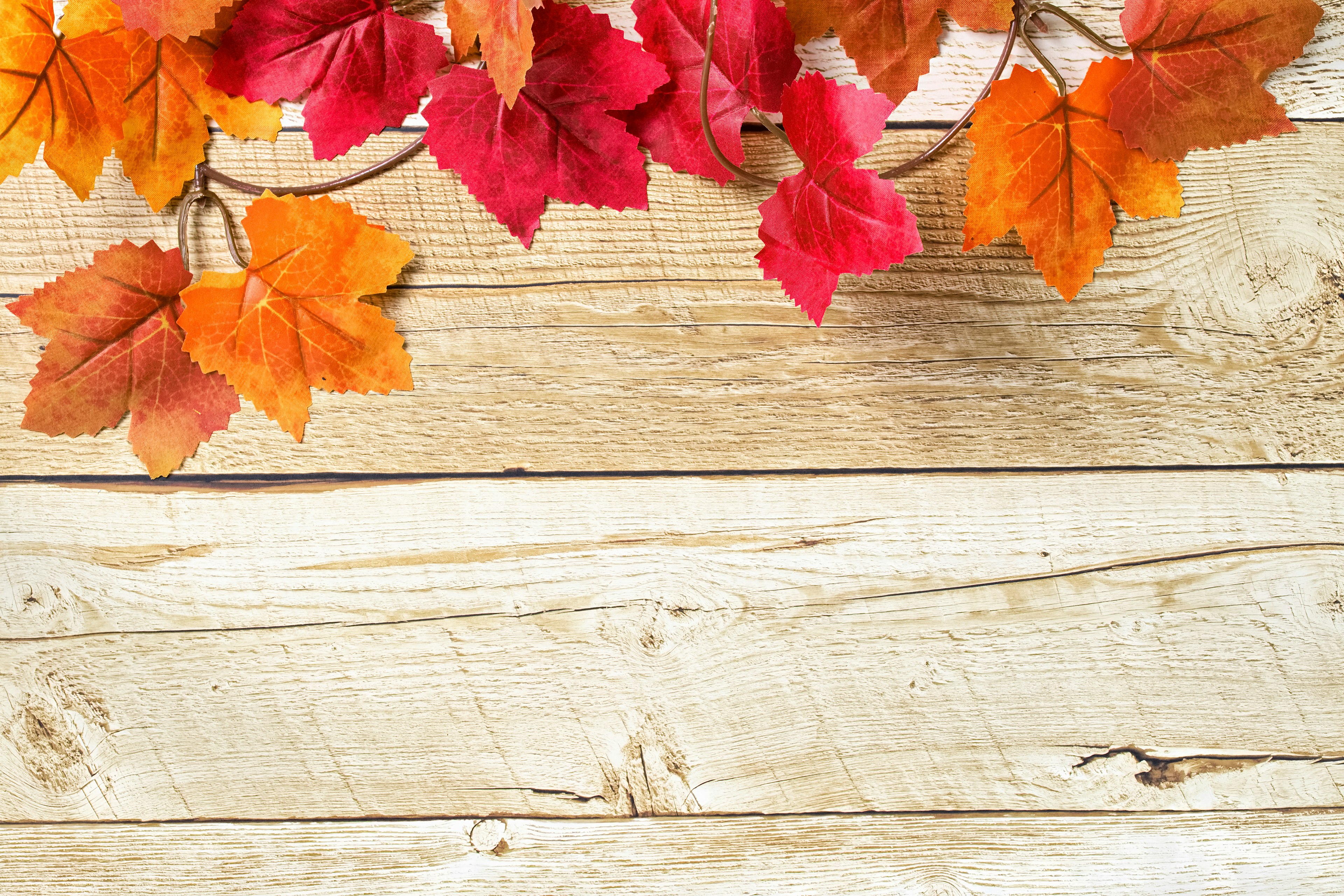 Autumn leaves in shades of red and orange on a wooden table