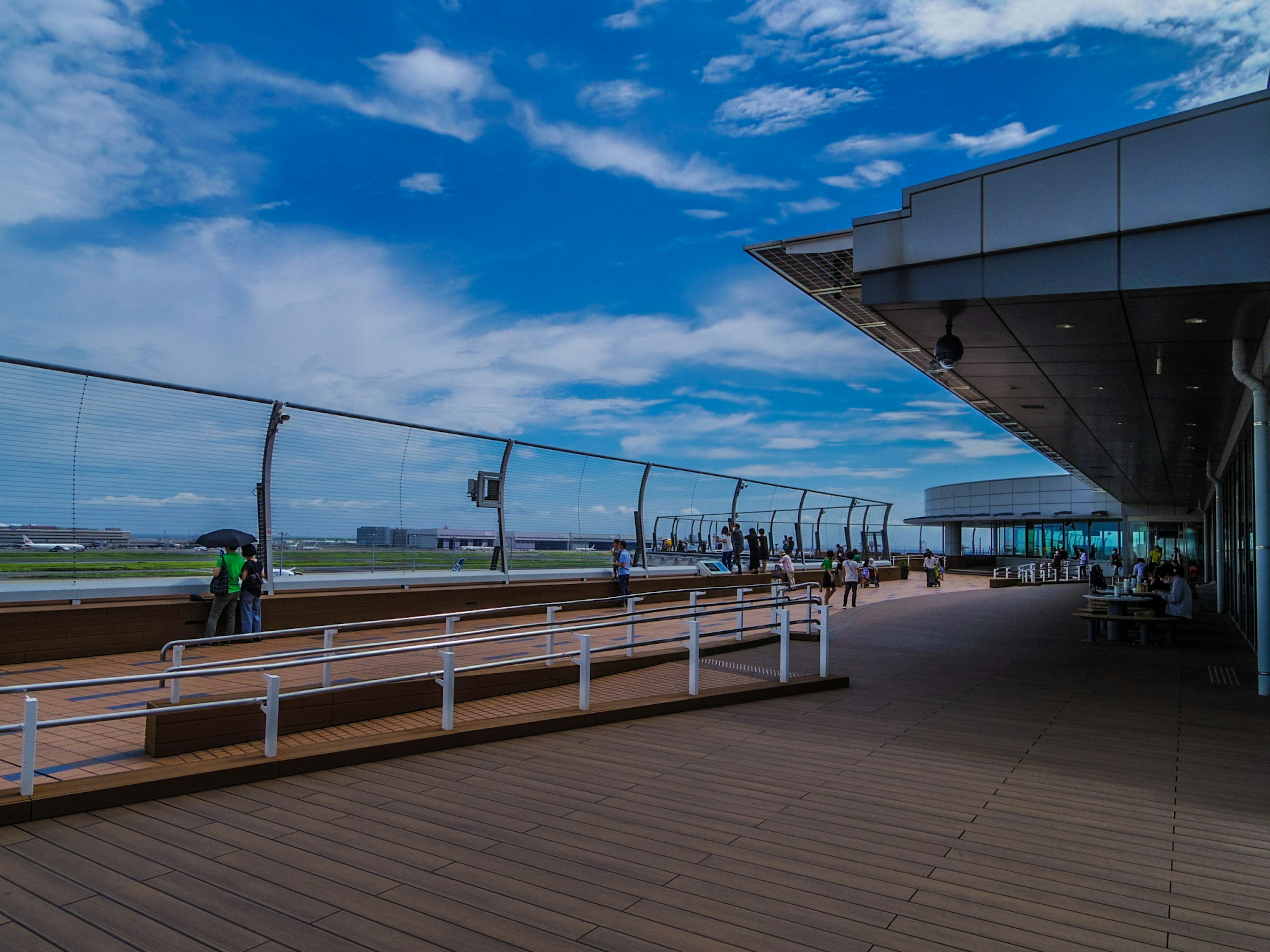 Amplia terraza de observación del aeropuerto con arquitectura moderna y cielo azul claro