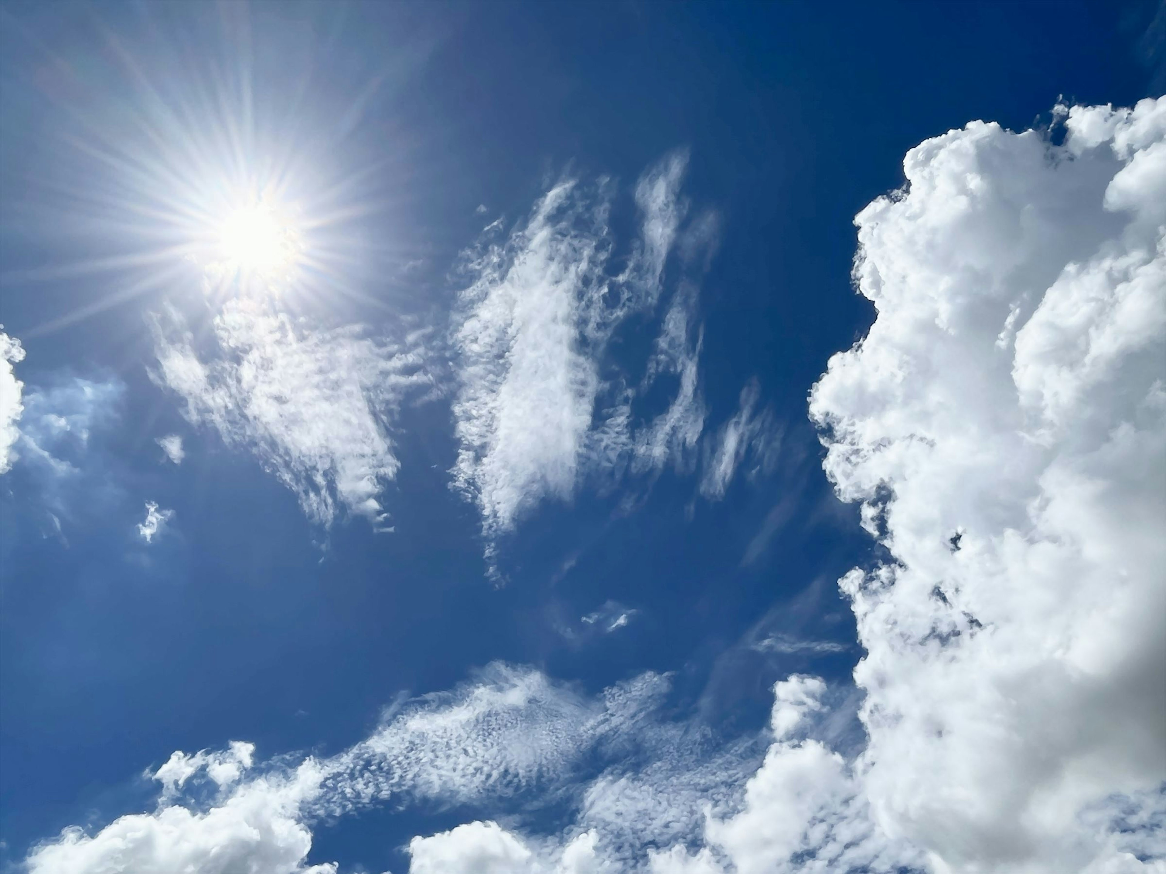 Cielo blu luminoso con nuvole bianche e sole splendente