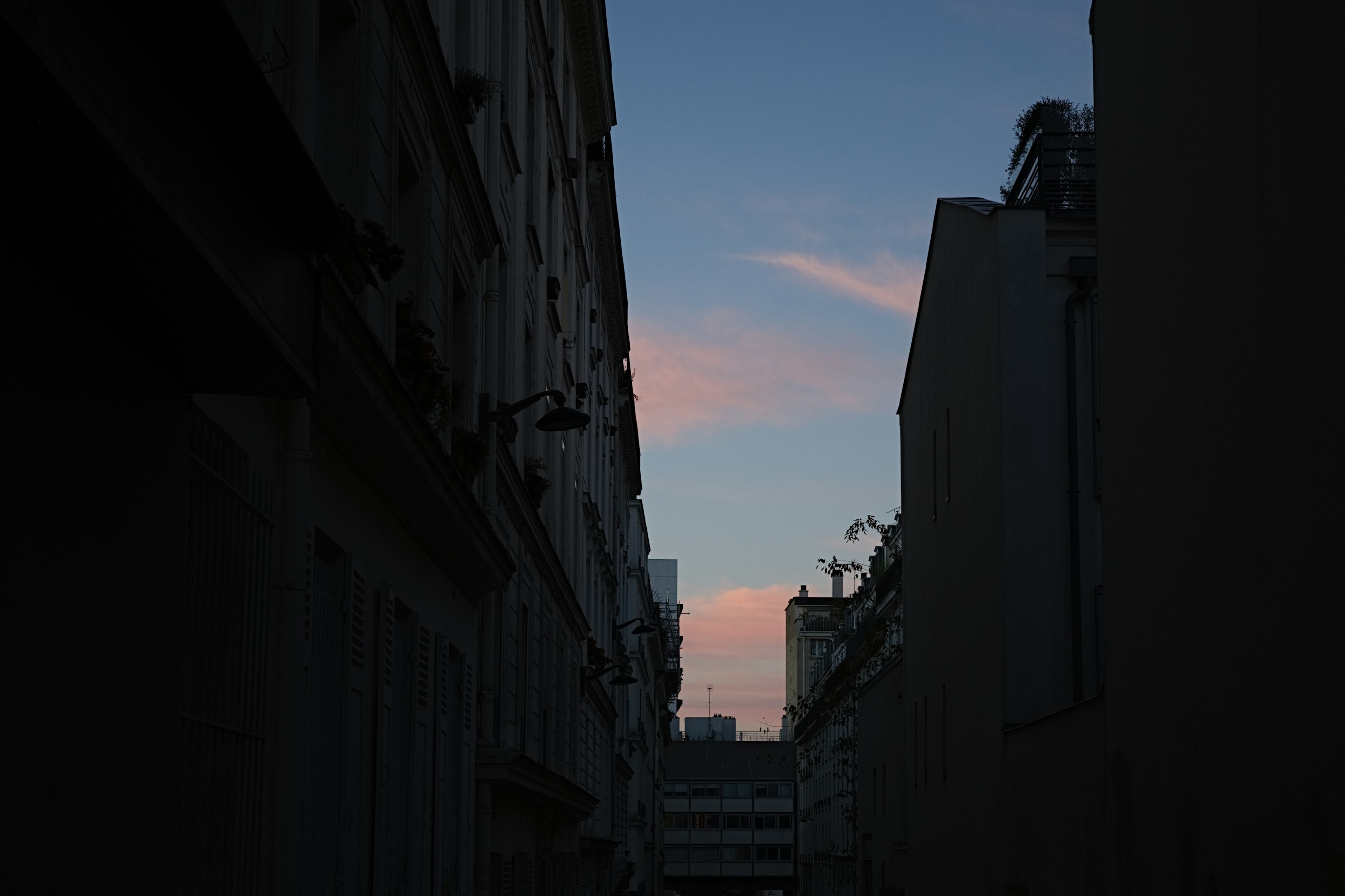 Silhouette einer engen Gasse mit Sonnenuntergangshimmel