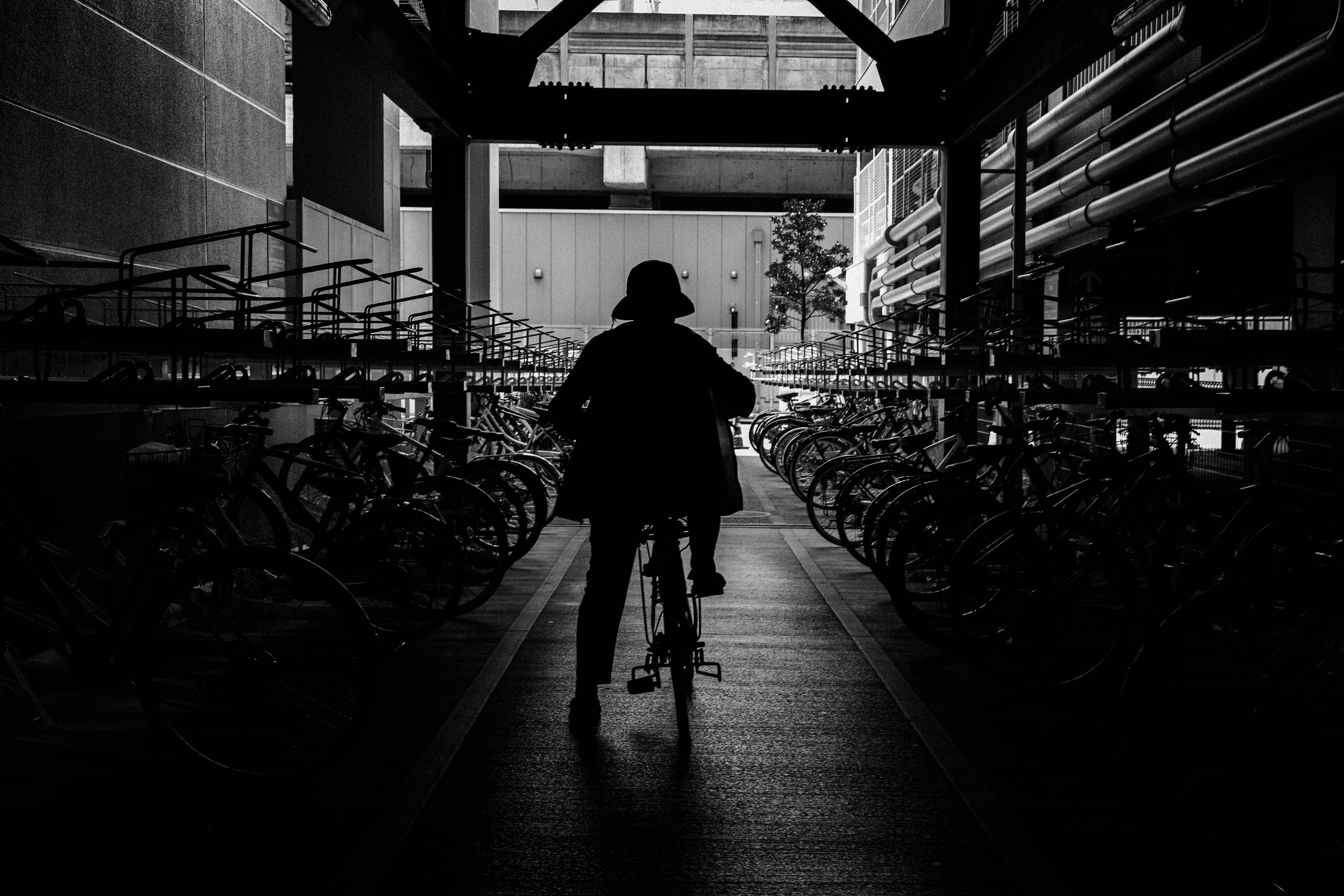 Silhouette of a person riding a bicycle in a black and white environment