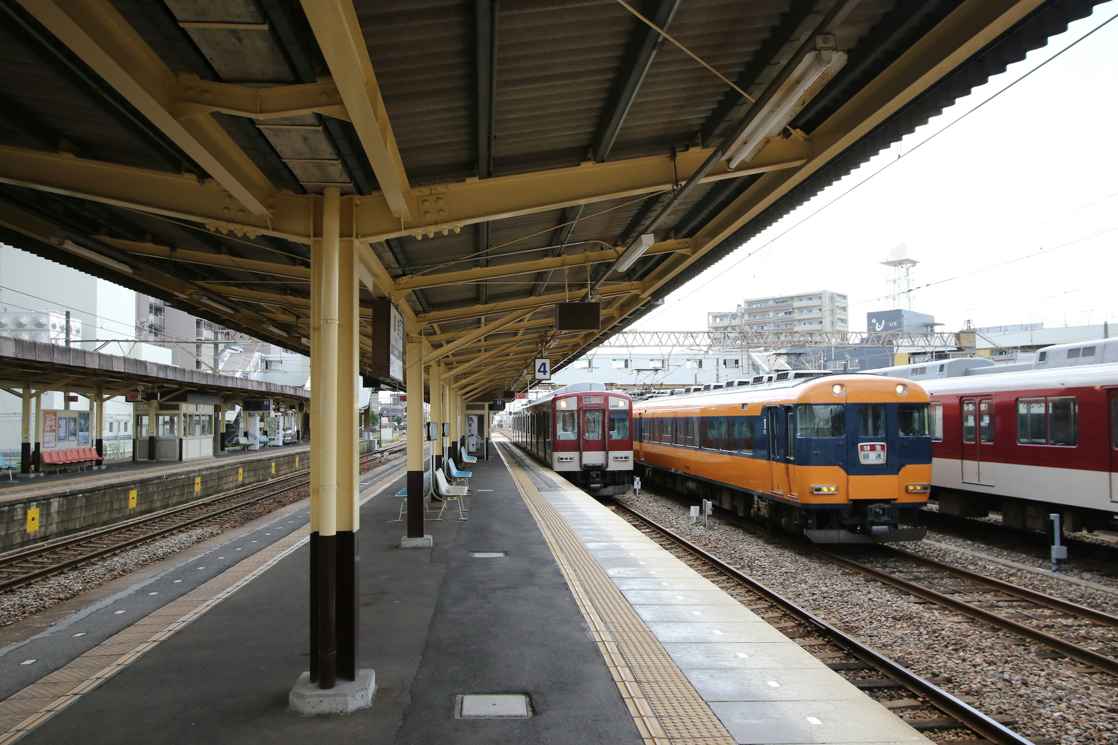 Piattaforma della stazione con treni parcheggiati e struttura del tetto