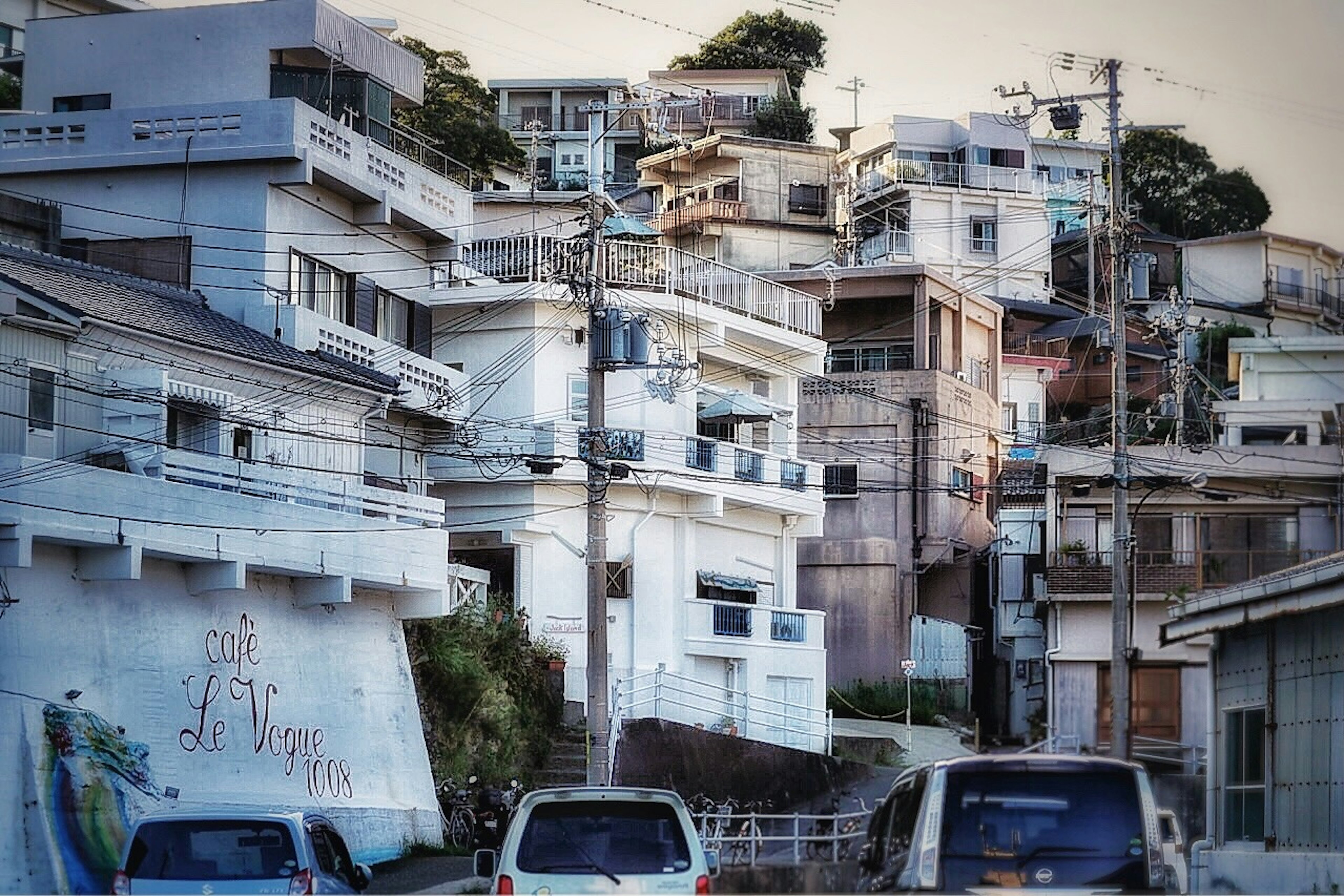 白い建物と狭い道路が特徴的な住宅街の風景