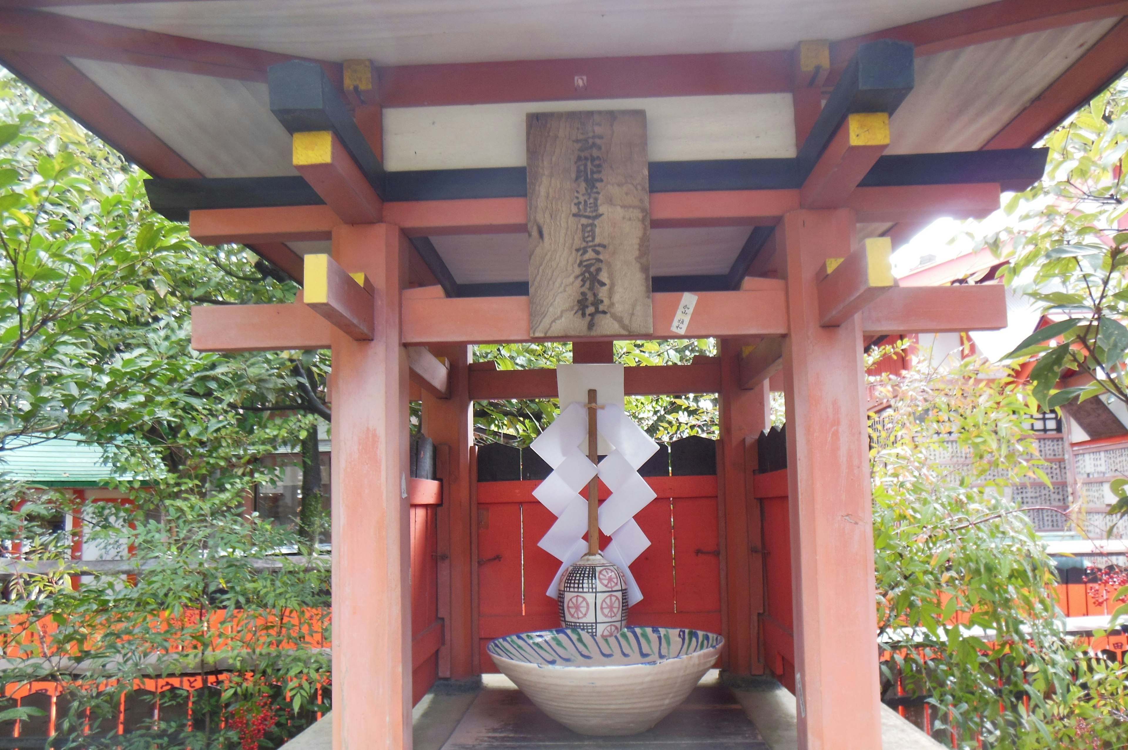 Un bassin d'eau de sanctuaire avec des piliers rouges et des décorations blanches