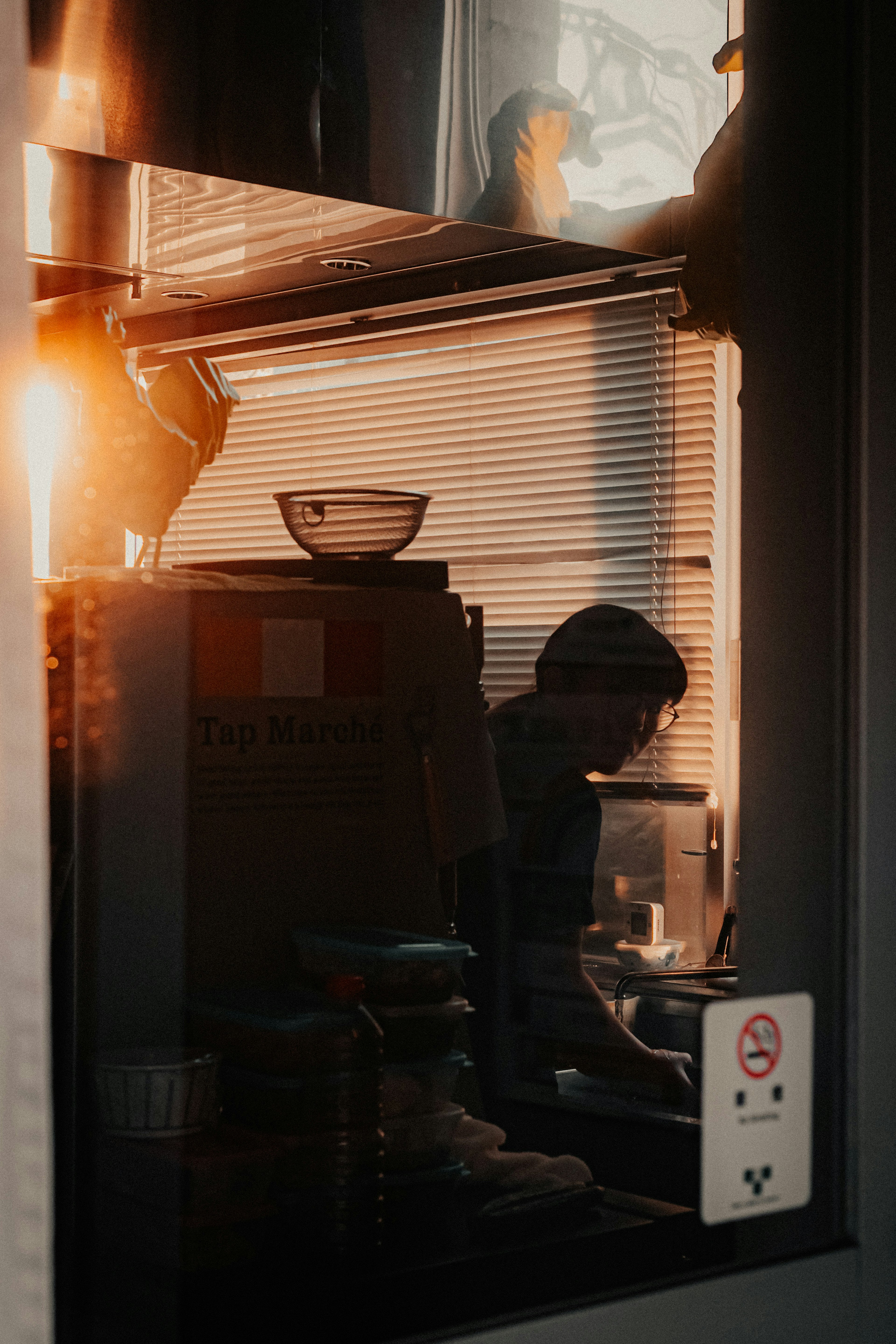 Silhouette d'une personne travaillant dans une cuisine avec la lumière du soleil