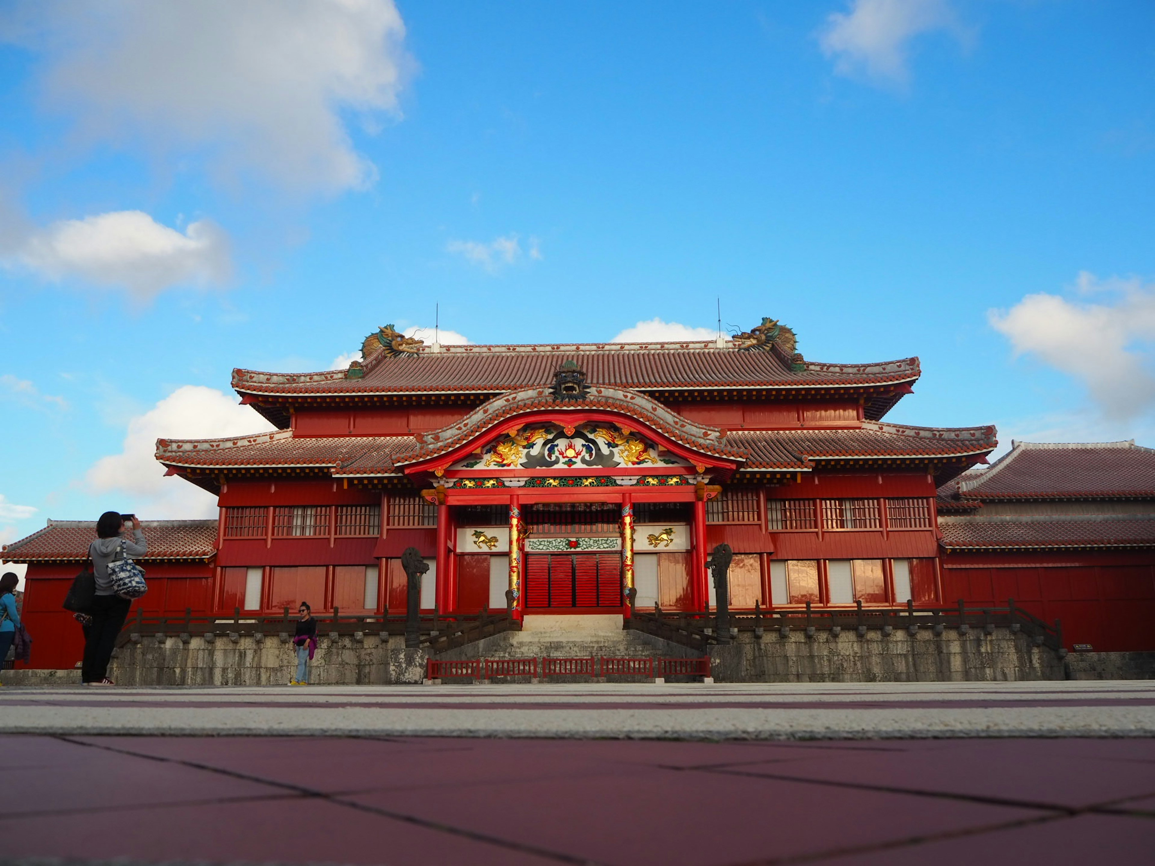 Front view of a traditional building with a red roof and ornate decorations