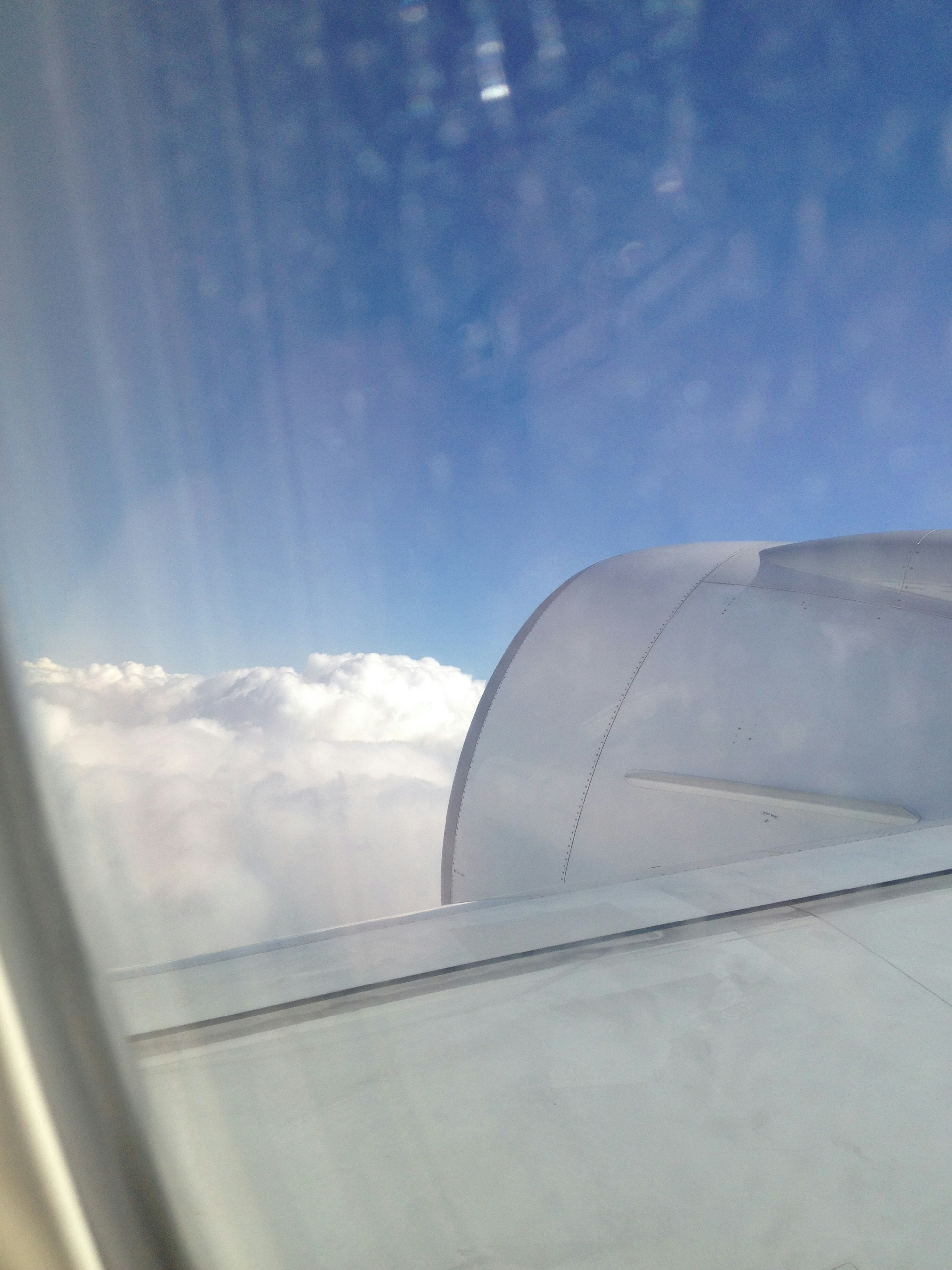 飛行機の窓から見える雲と青い空の景色