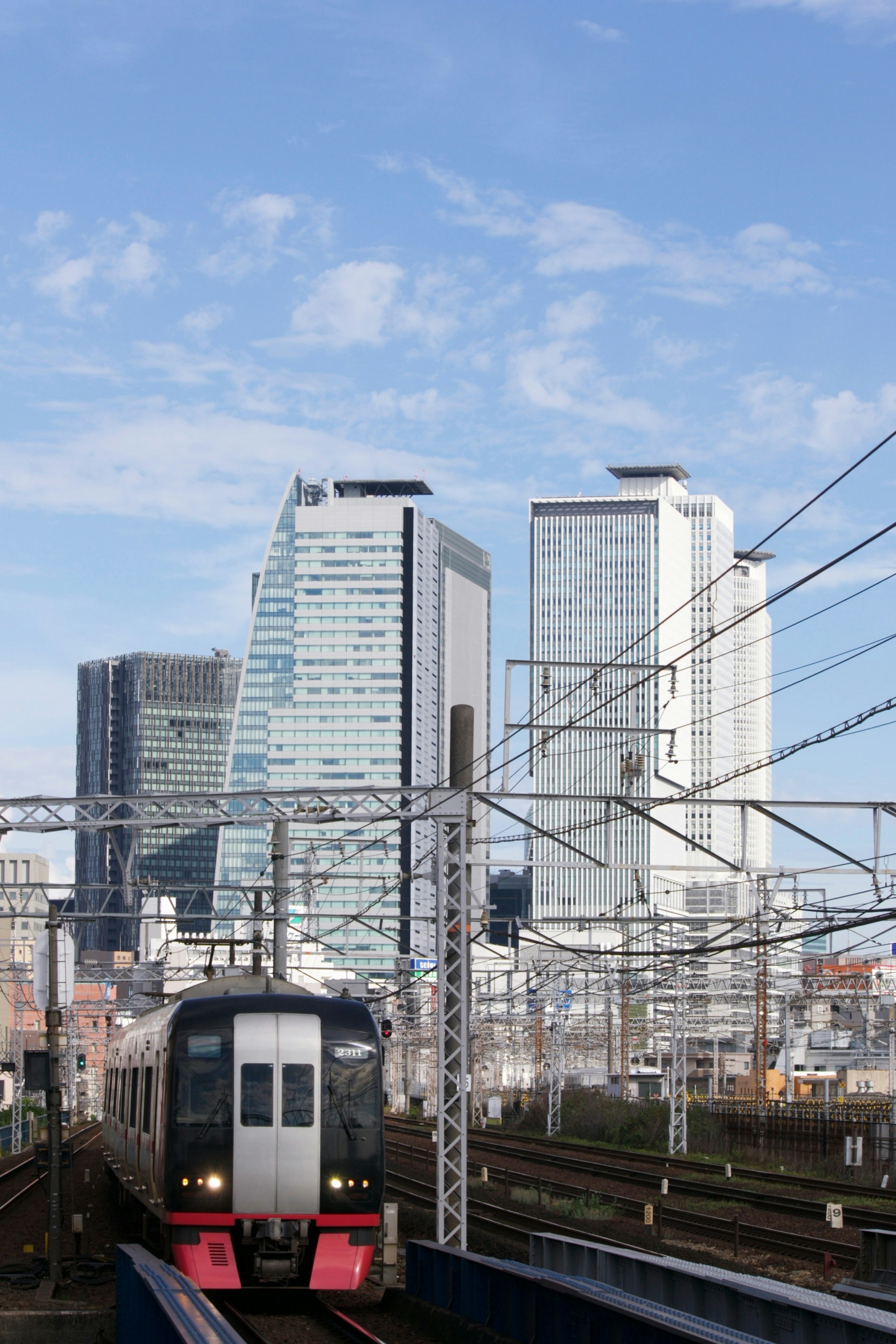 Imagen de un tren en un paisaje urbano con rascacielos modernos