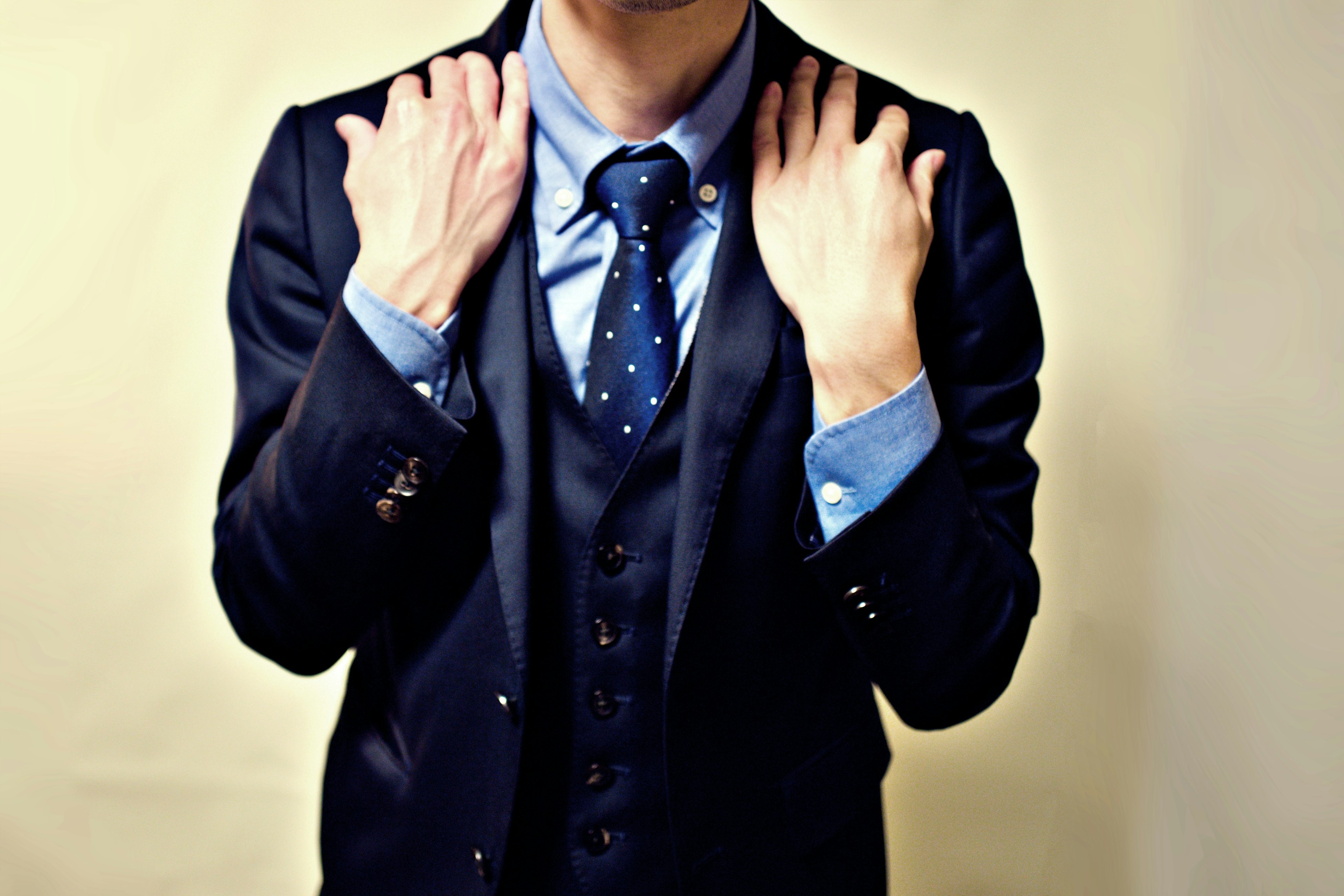 A man in a suit showing his upper body with hands on shoulders Stylish suit and tie with a light blue shirt