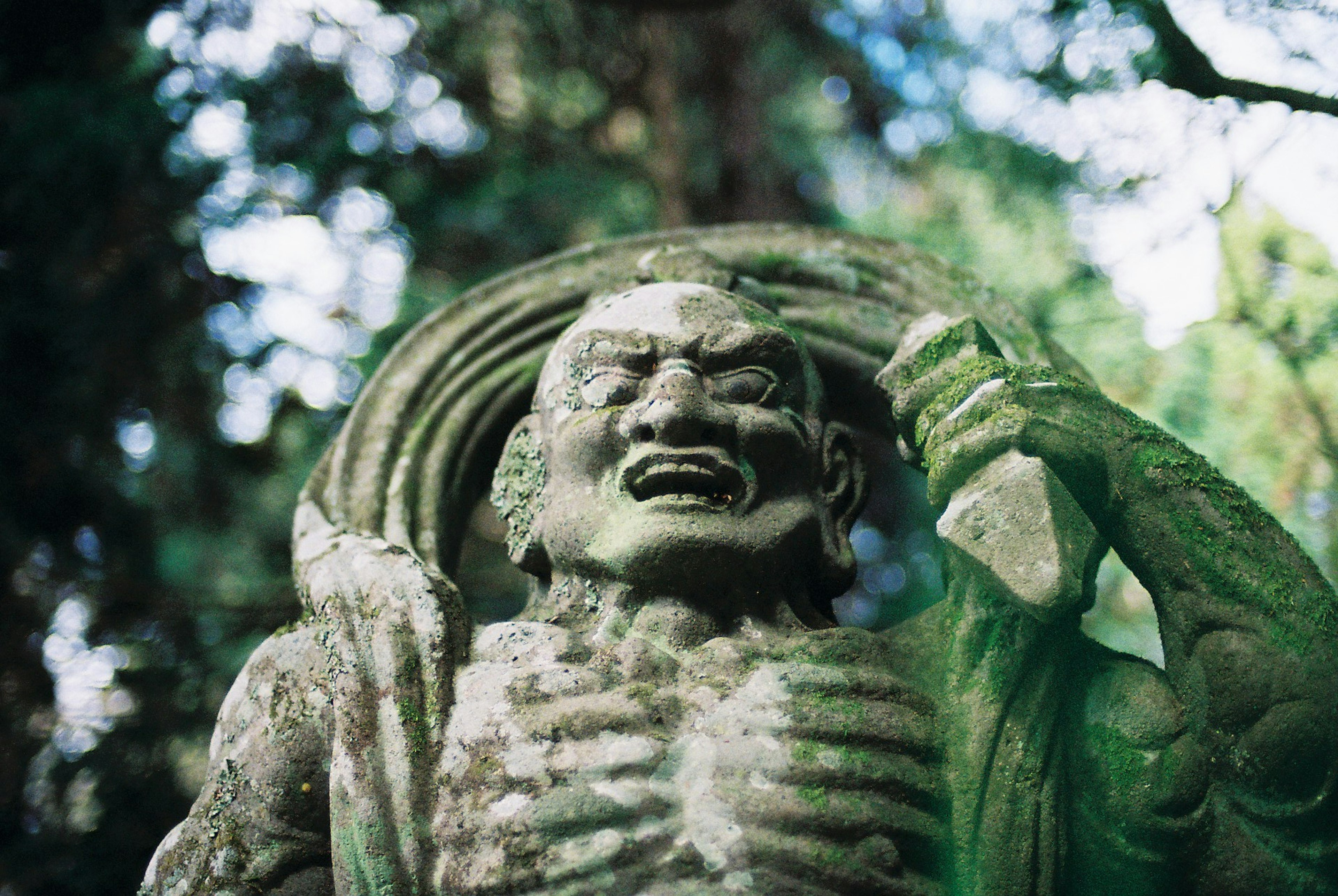 Statue en pierre verte d'un démon féroce tenant une épée