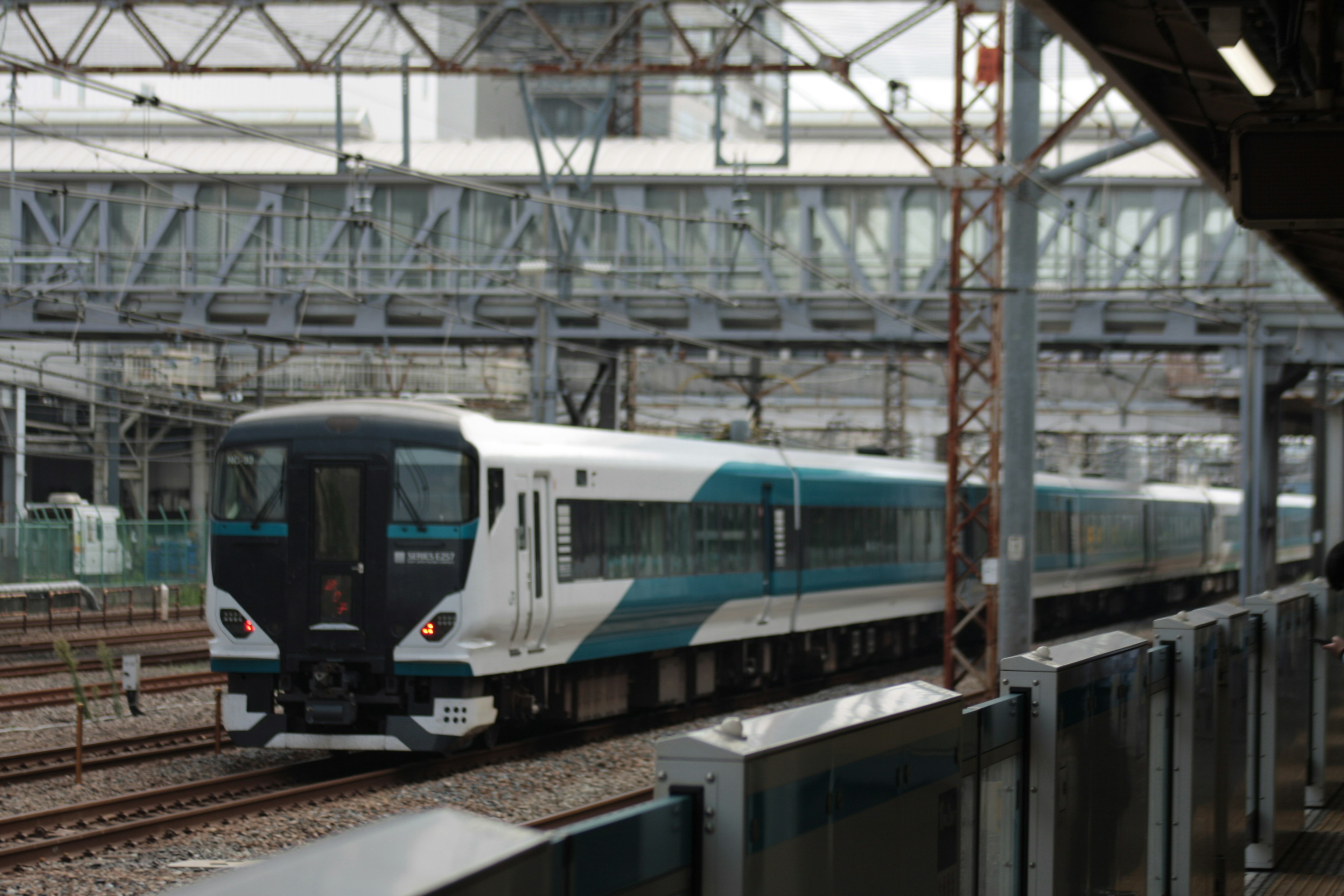 A white and blue train running on railway tracks