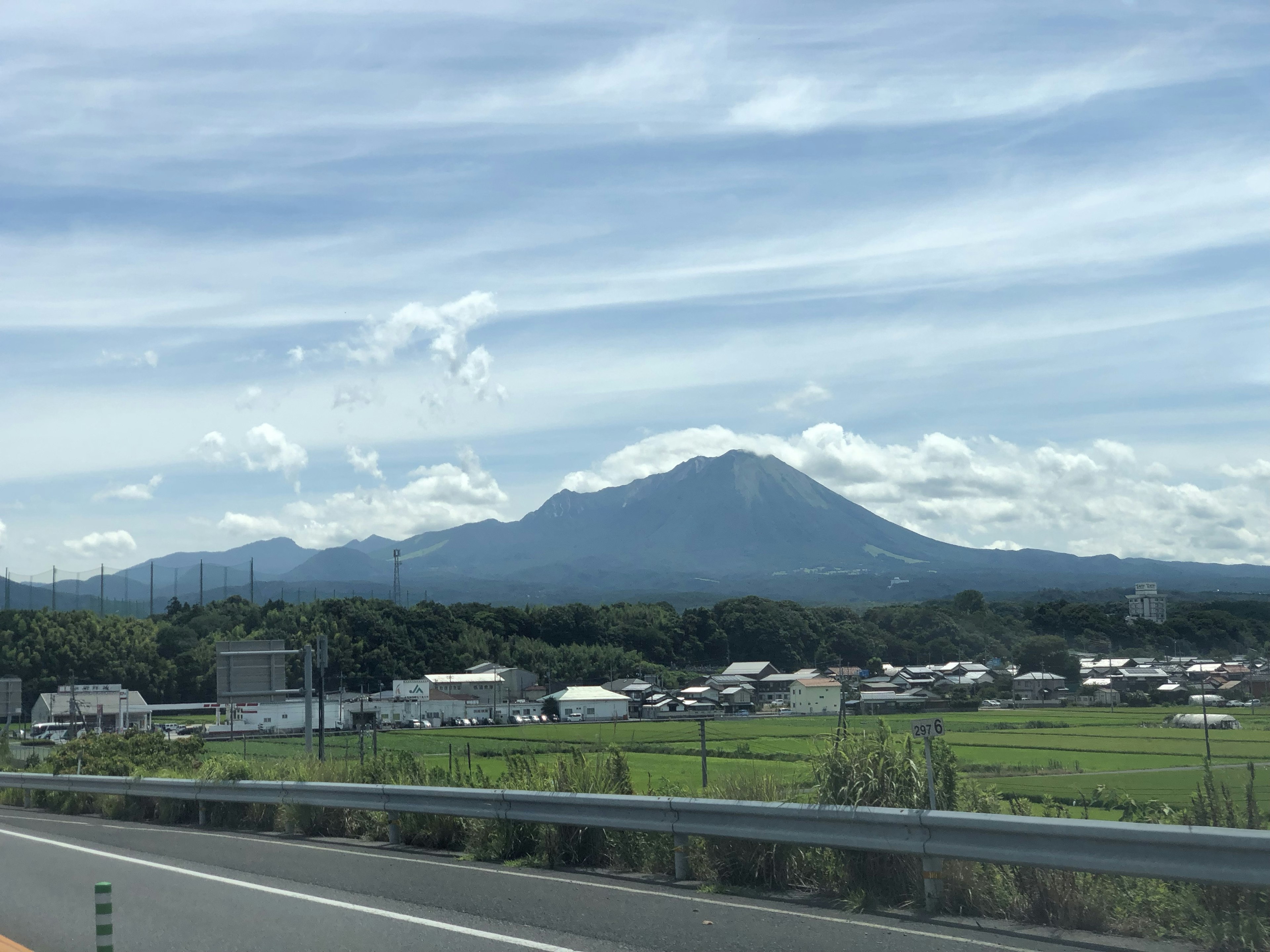 青い空と雲を背景にした山と田園風景