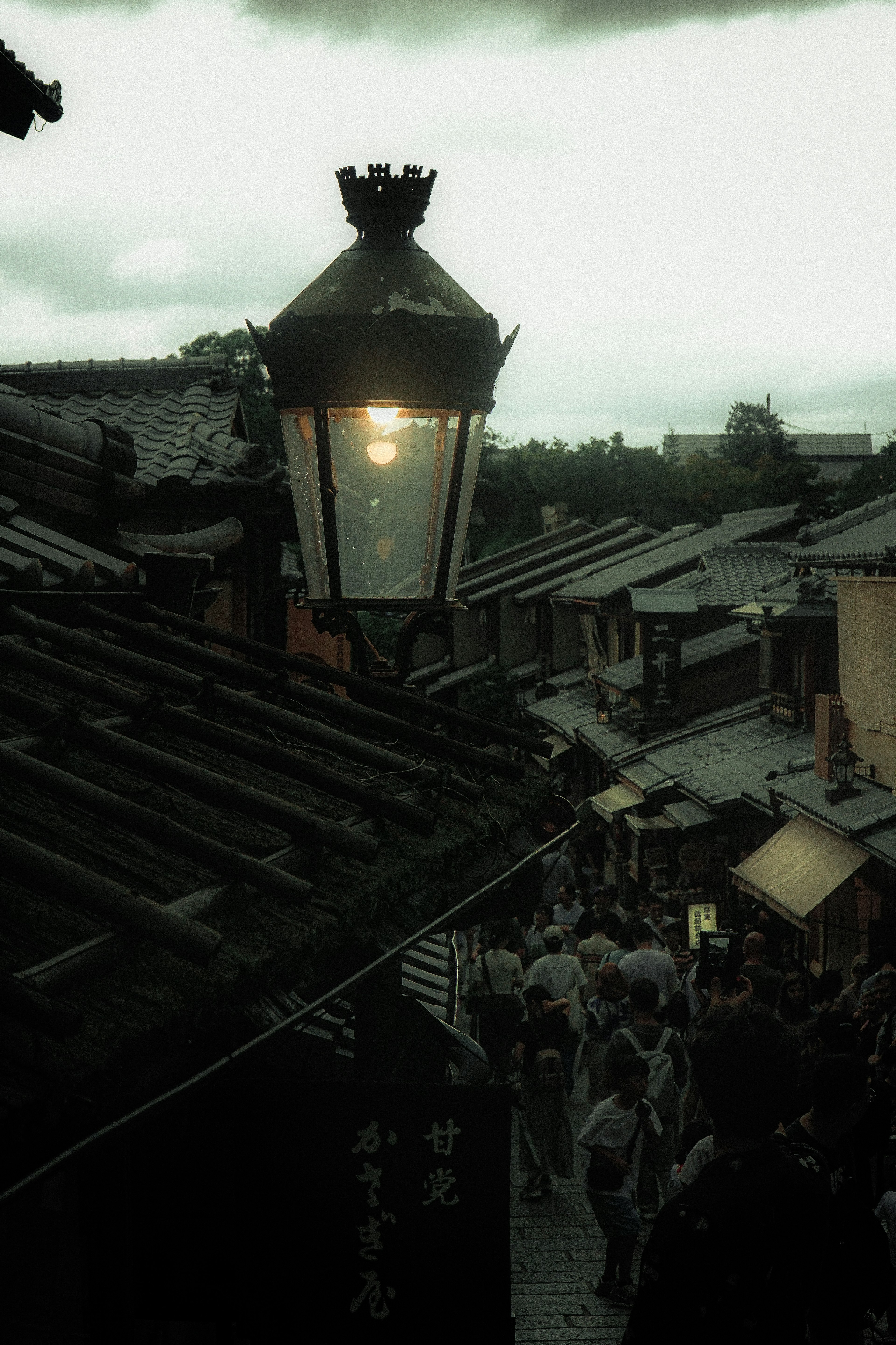 Evening street scene with a lantern and rooftops