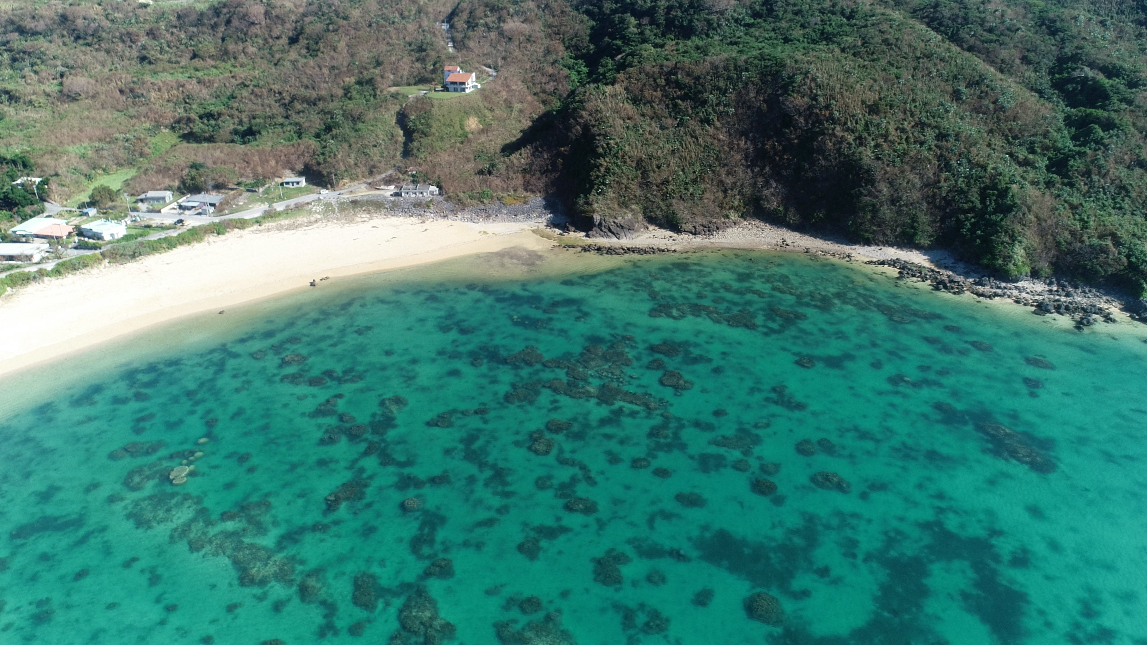 Vue aérienne d'une belle plage entourée d'eau bleue et de sable blanc