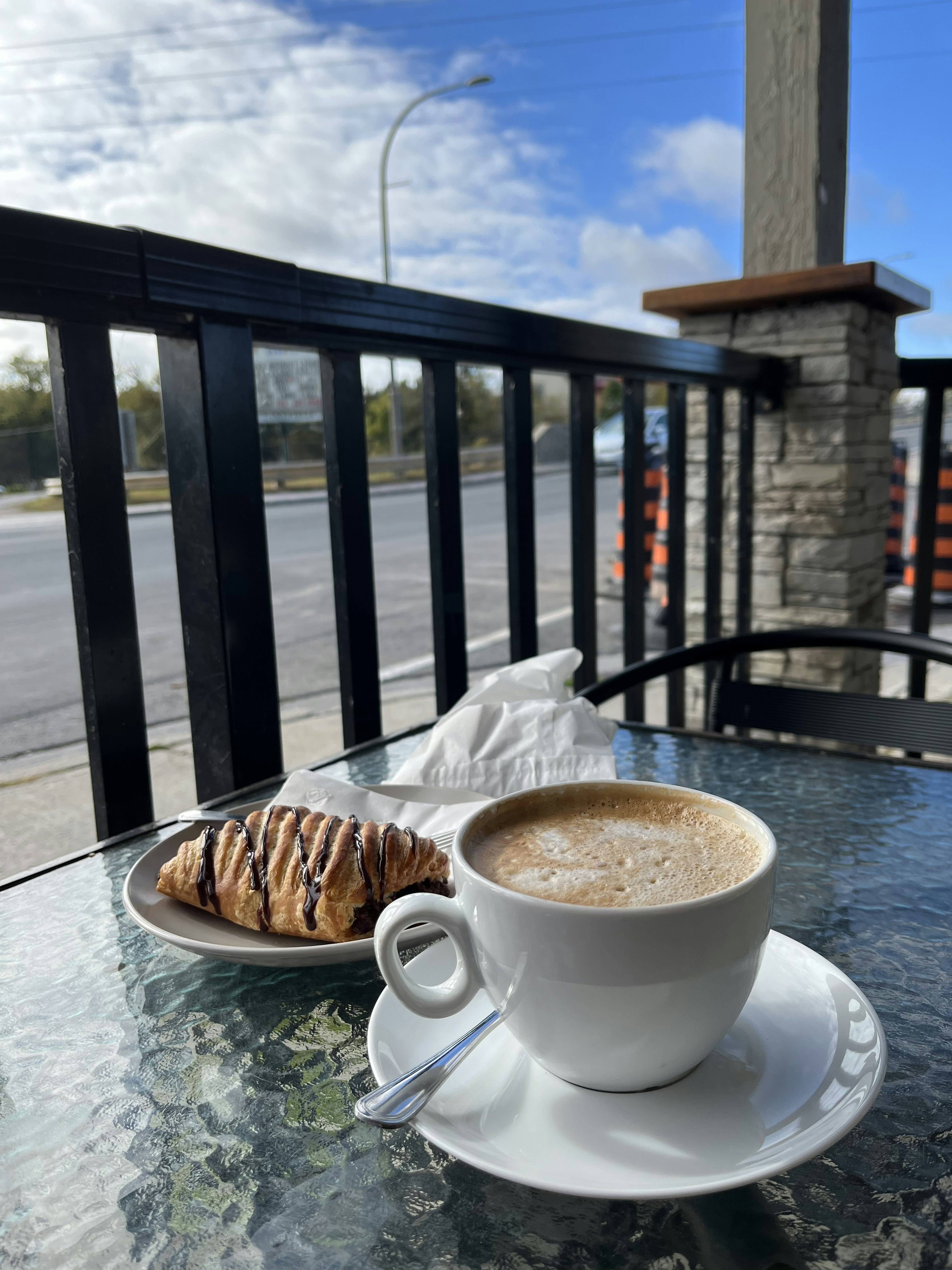 Una taza de café y un pastel en una mesa de un café al aire libre