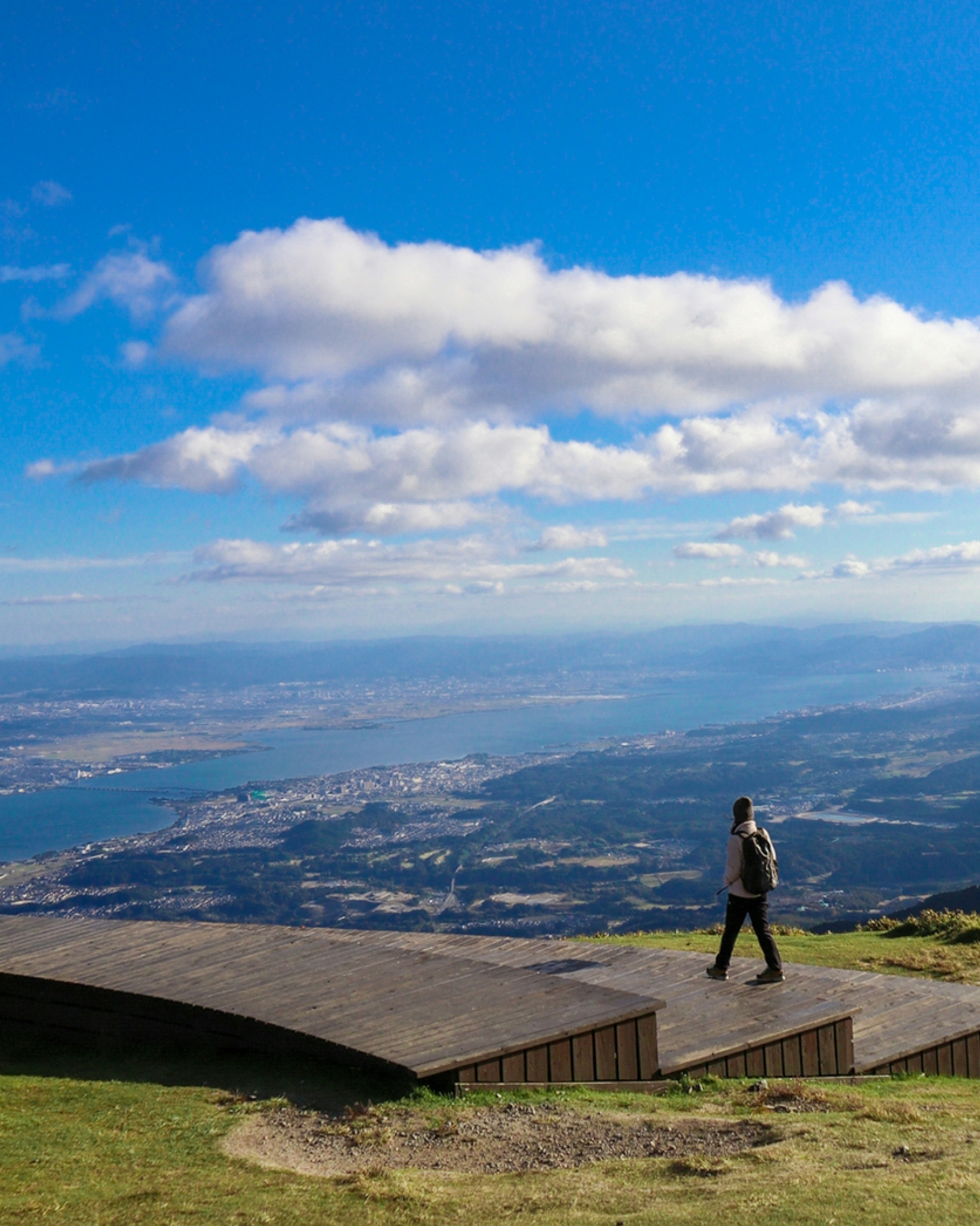 青い空と雲の下を歩く人が見える山の景色