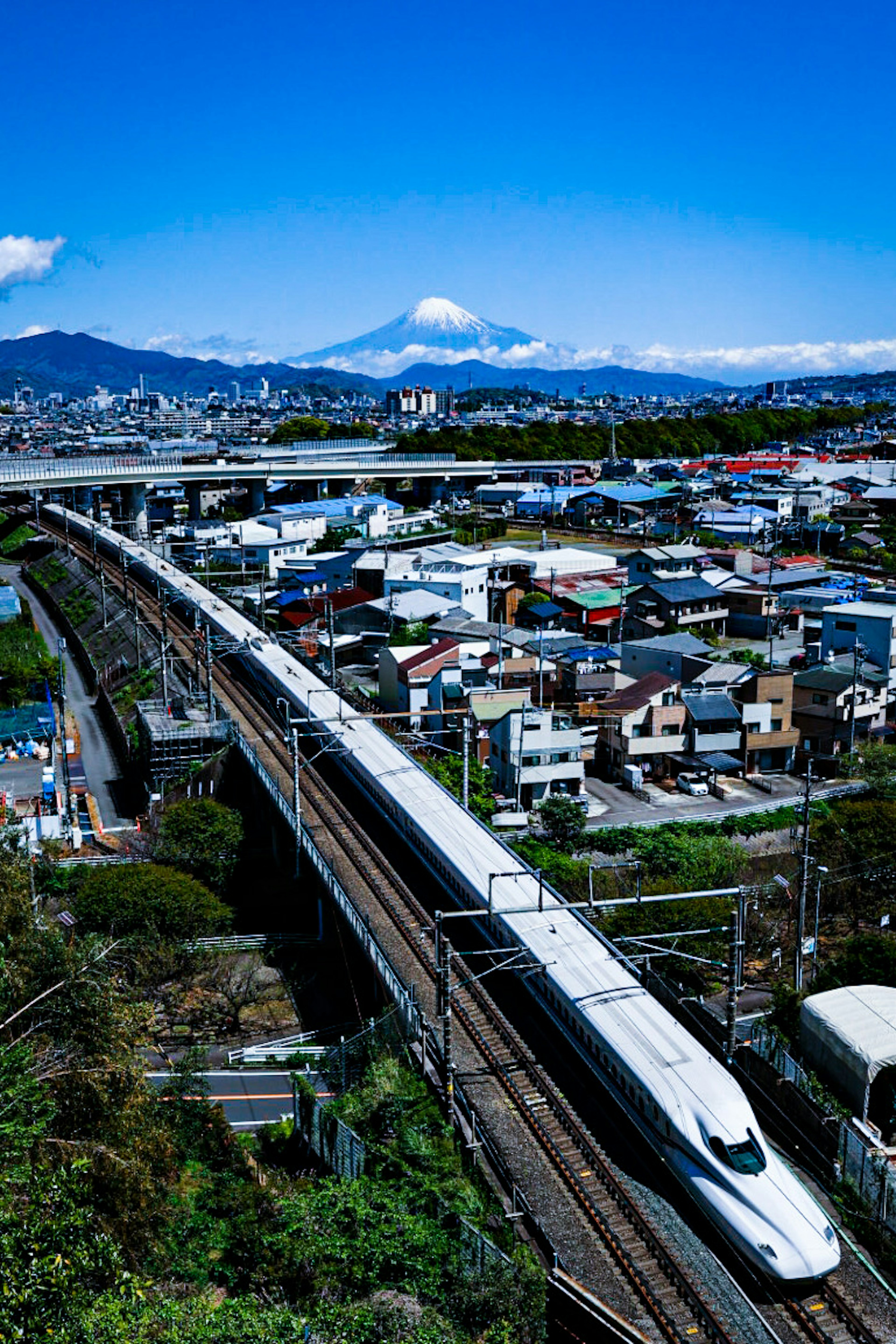 Cityscape featuring Shinkansen with Mount Fuji in the background