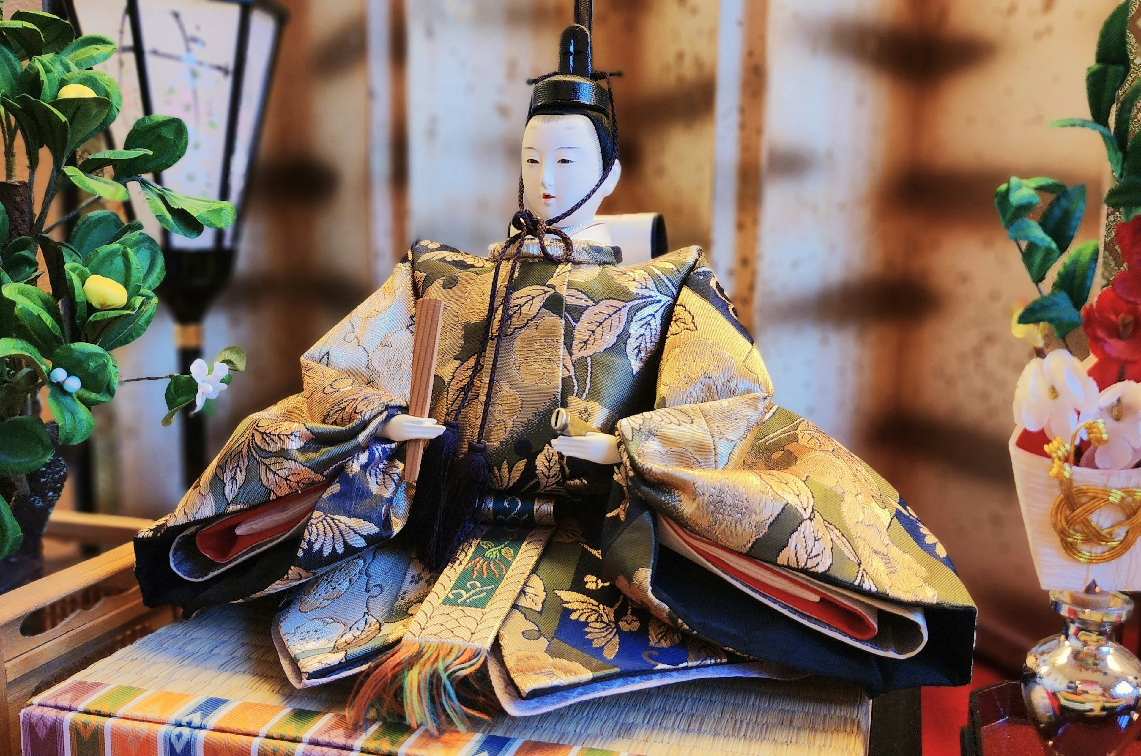 A traditional Japanese hina doll dressed in a beautiful kimono displayed indoors