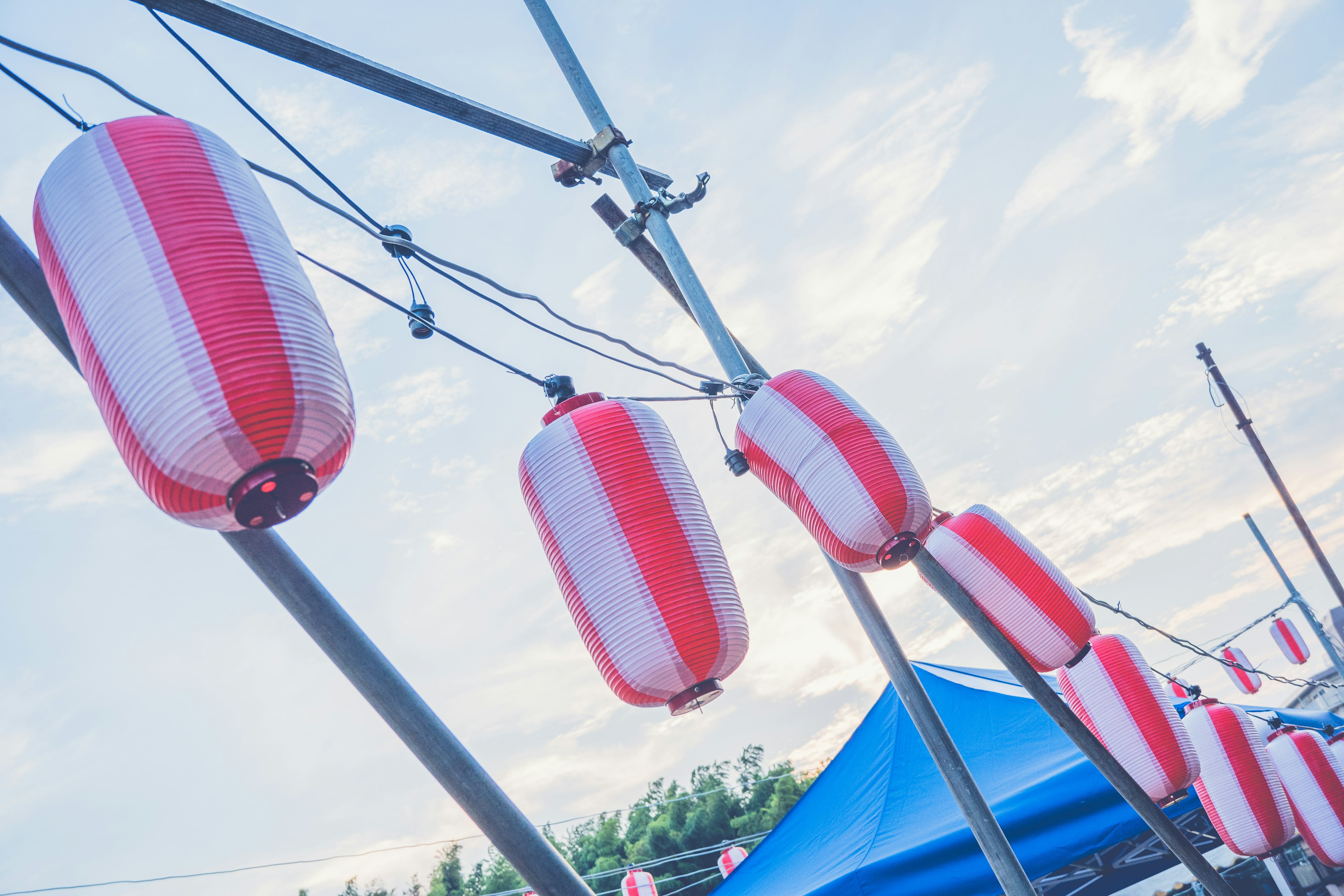 Red and white lanterns hanging under a blue sky