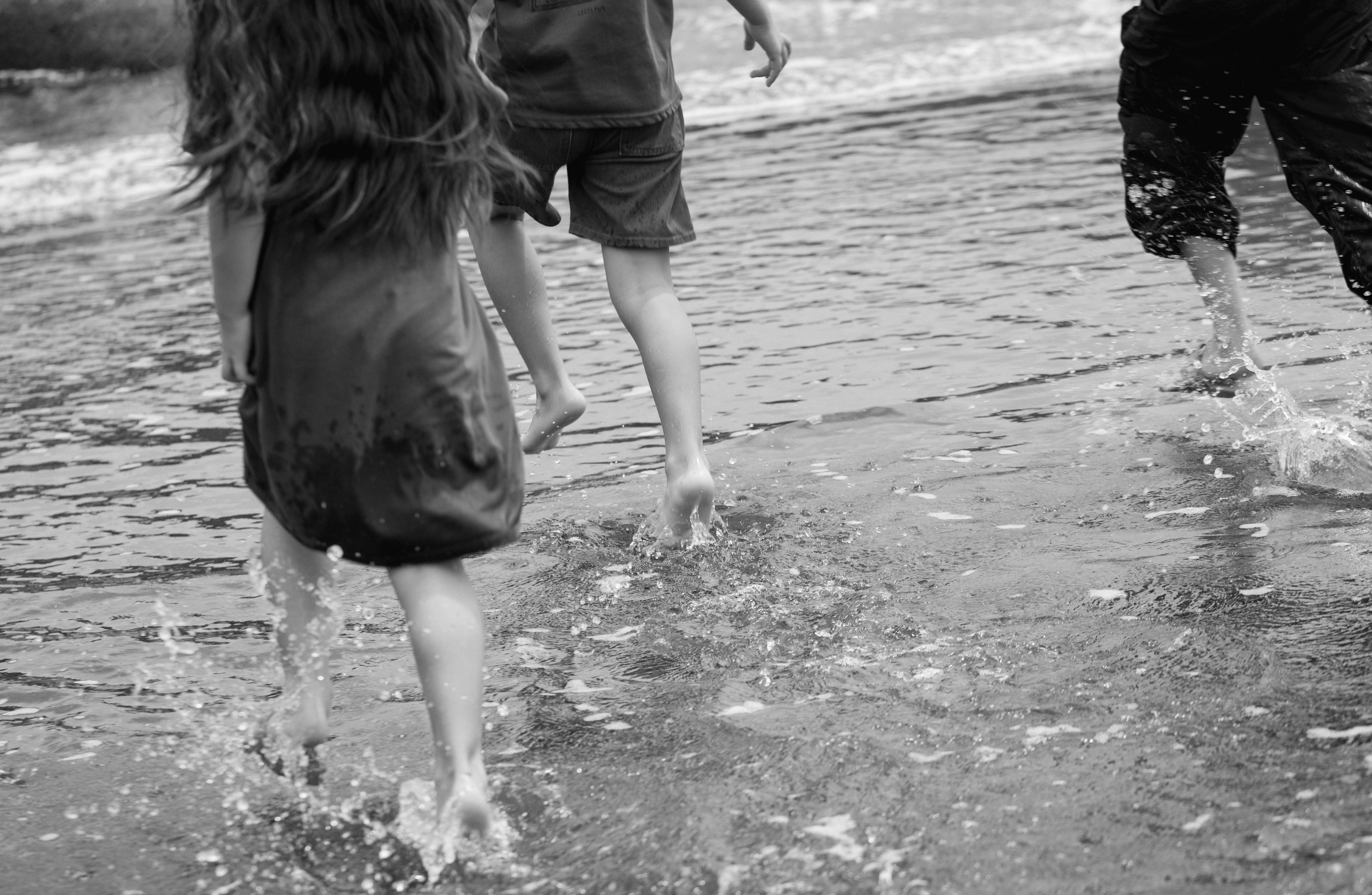 Niños jugando en el mar con olas y salpicaduras