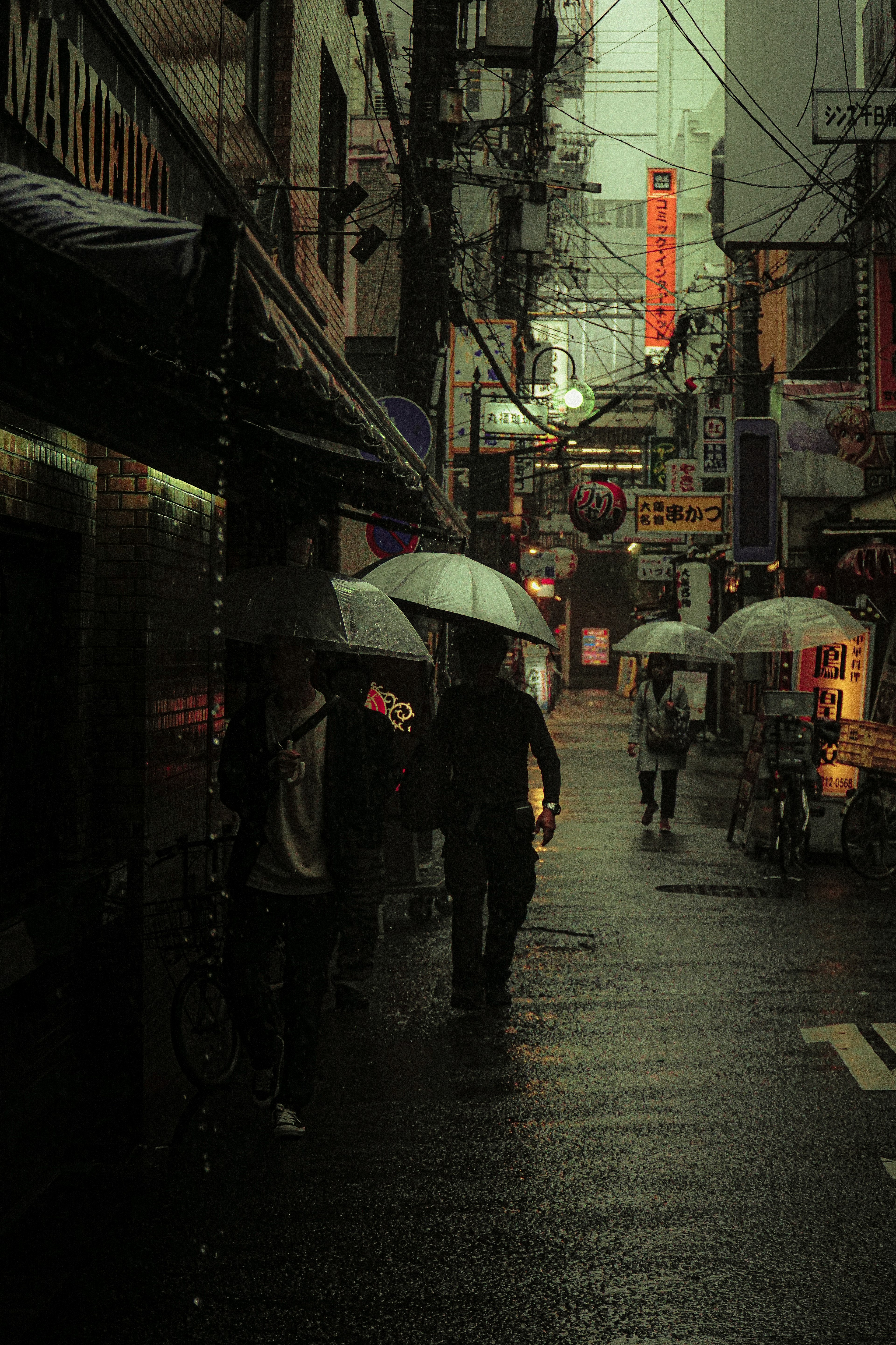 雨中街道場景，人們撐著傘