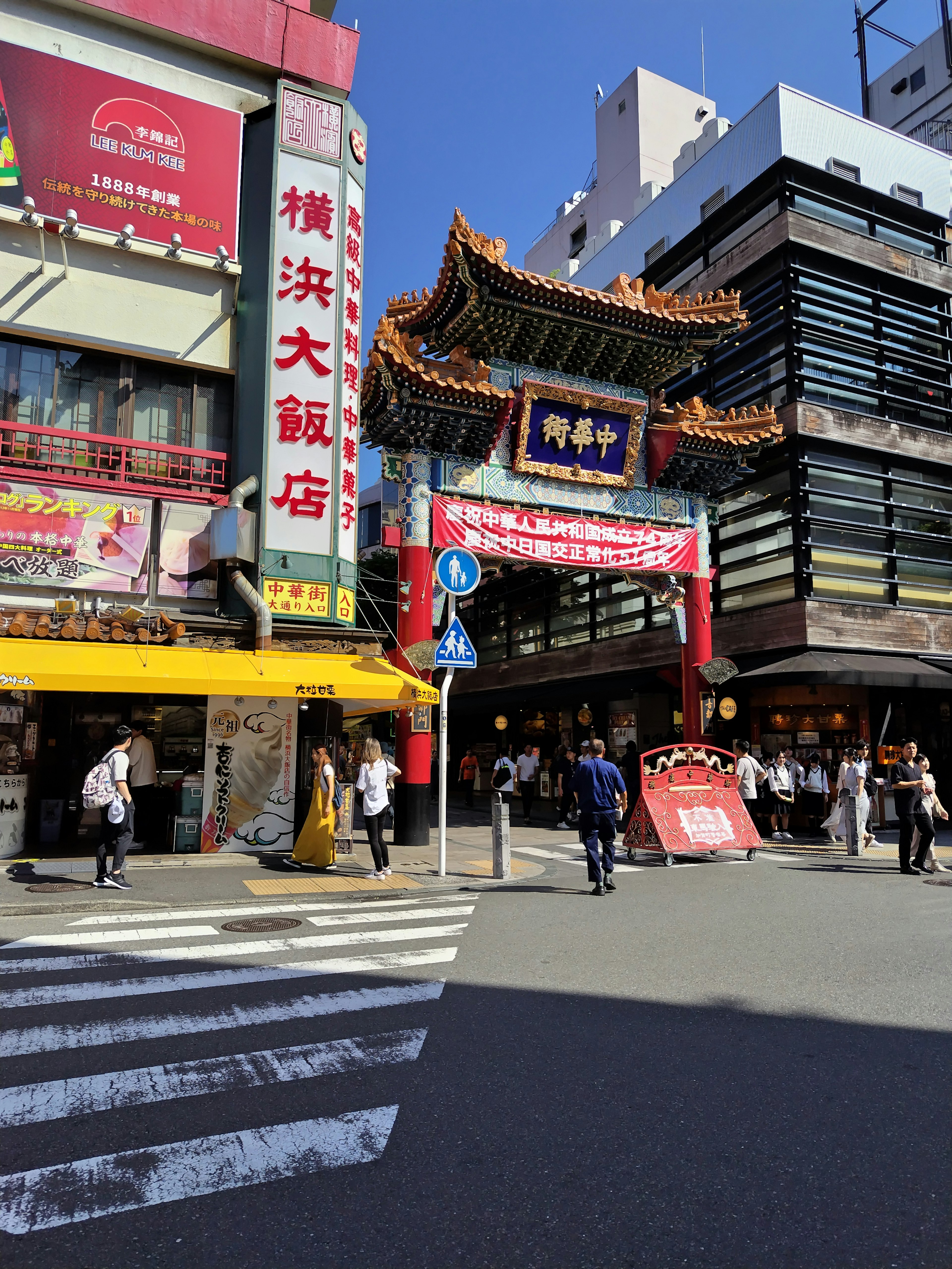 Bustling street view of Yokohama Chinatown entrance with pedestrians