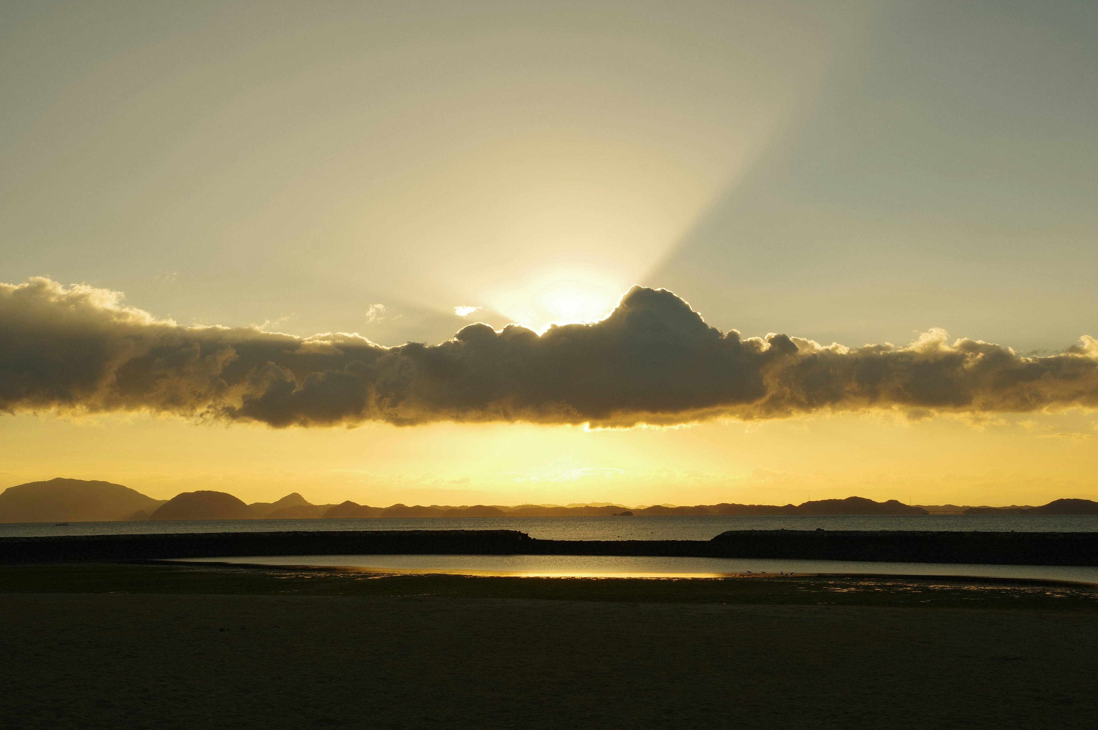 Bellissimo paesaggio con i raggi del tramonto dietro le nuvole