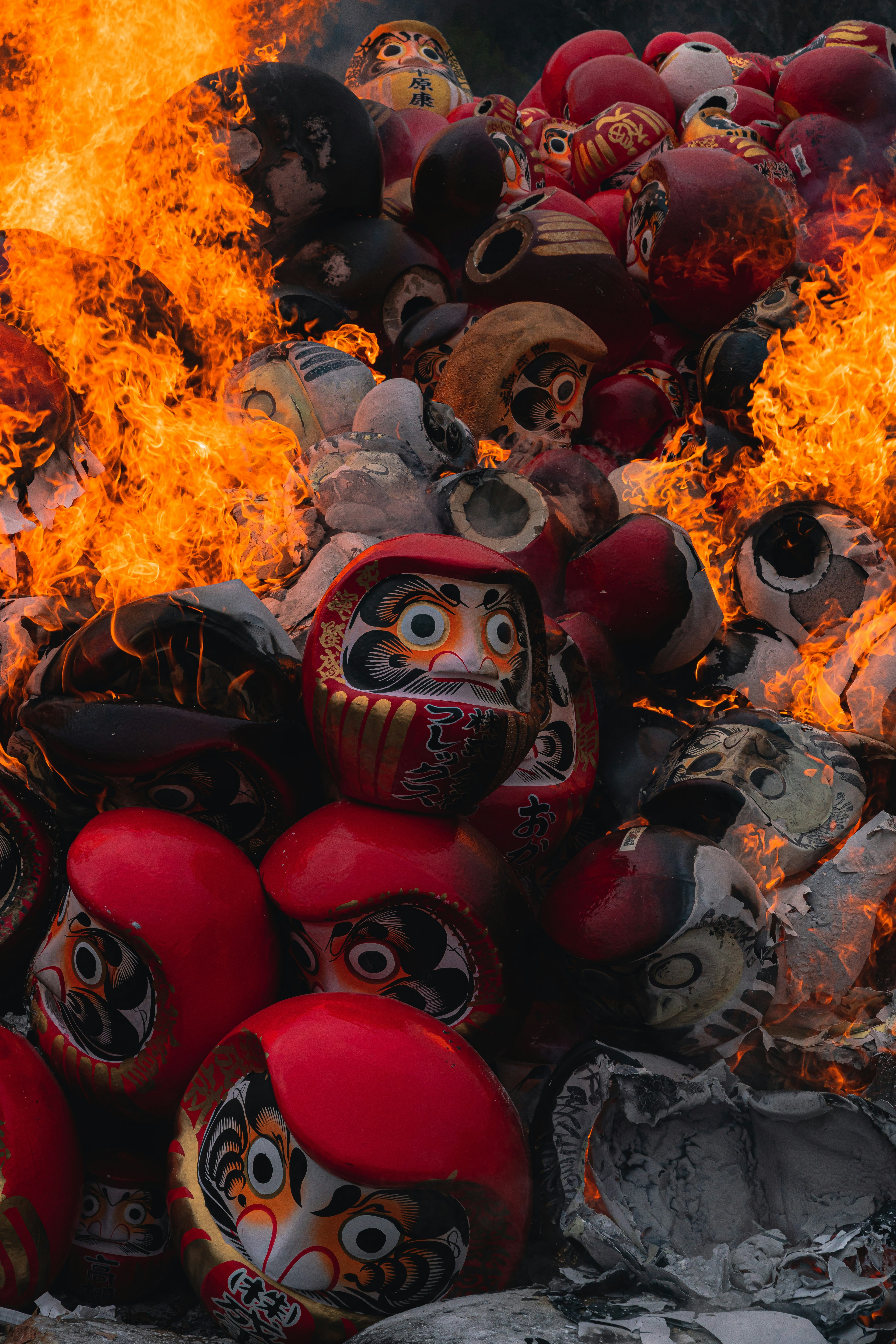 Una pila de muñecas Daruma envueltas en llamas