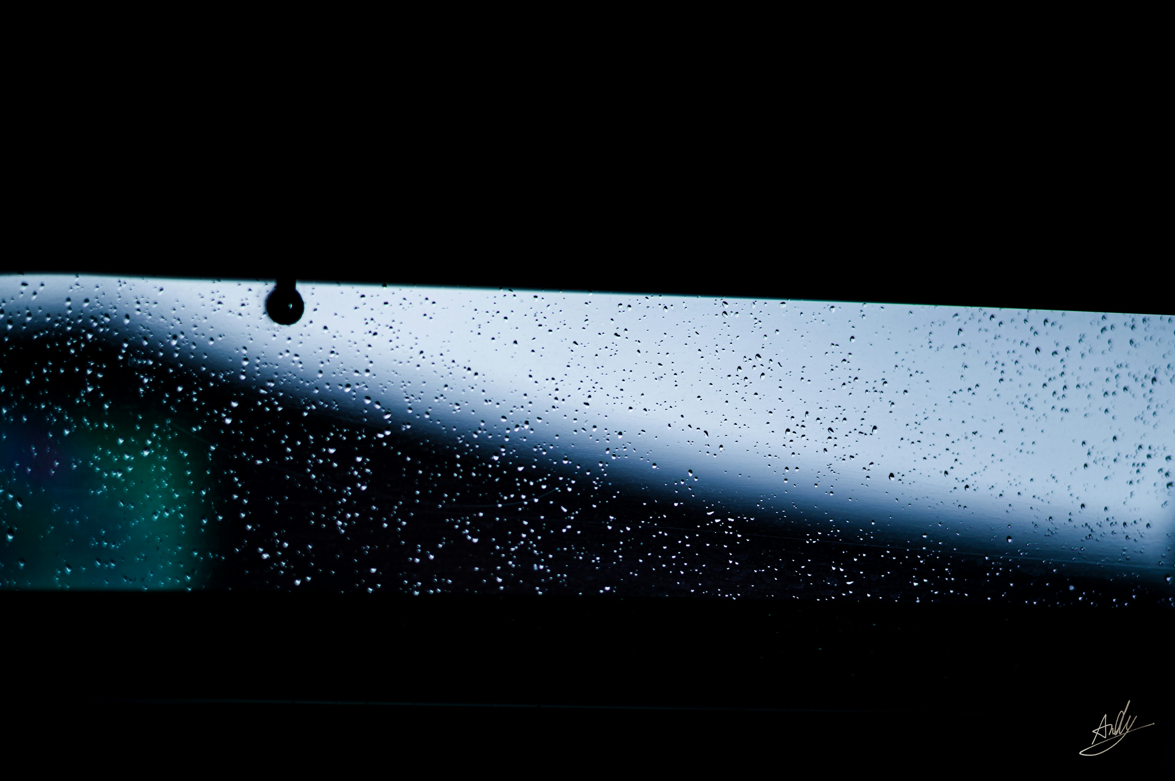 Dunkle Ansicht von Regentropfen an einem Fenster mit verschwommenem Hintergrund