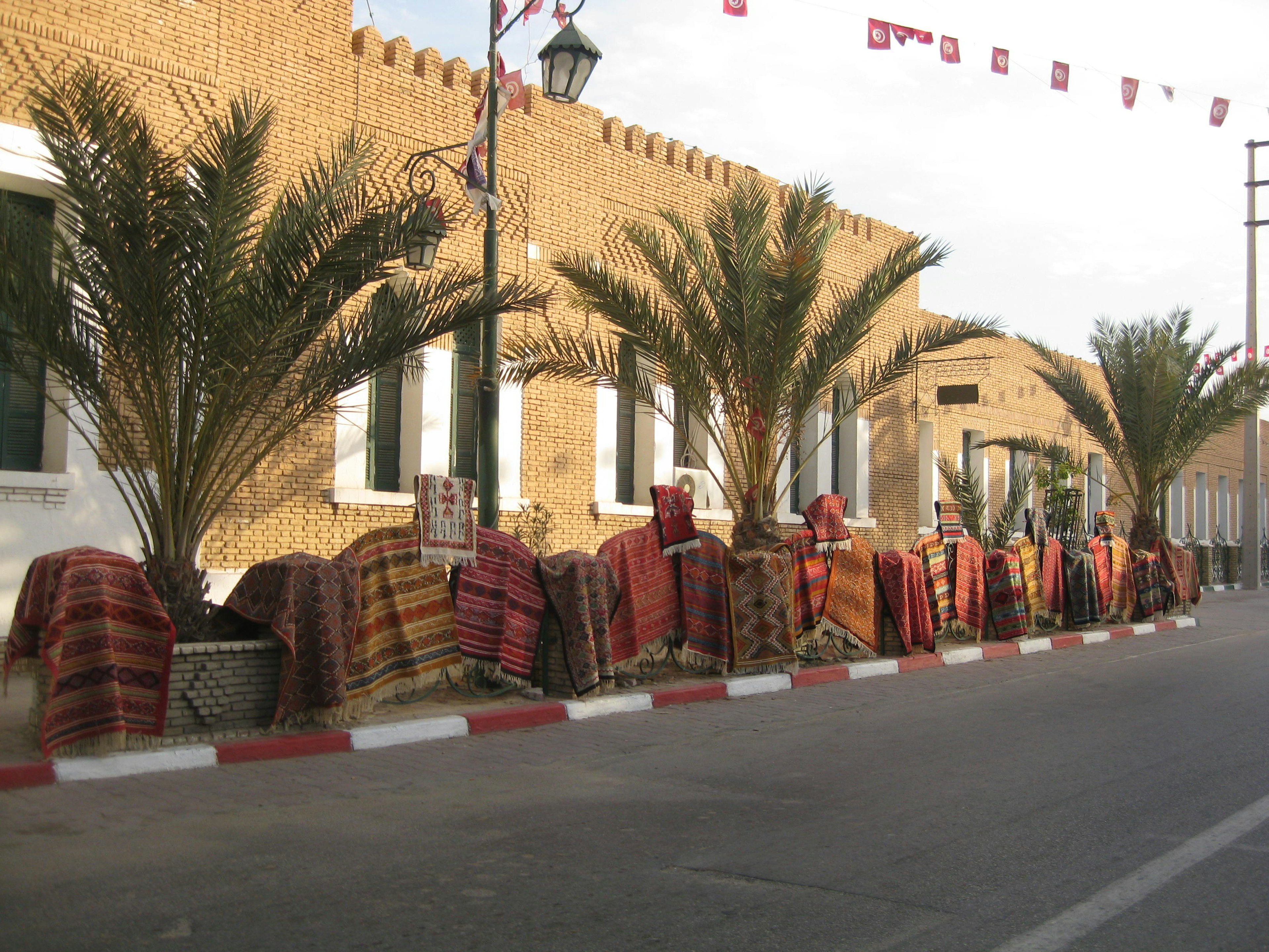 Street view with palm trees covered in colorful textiles