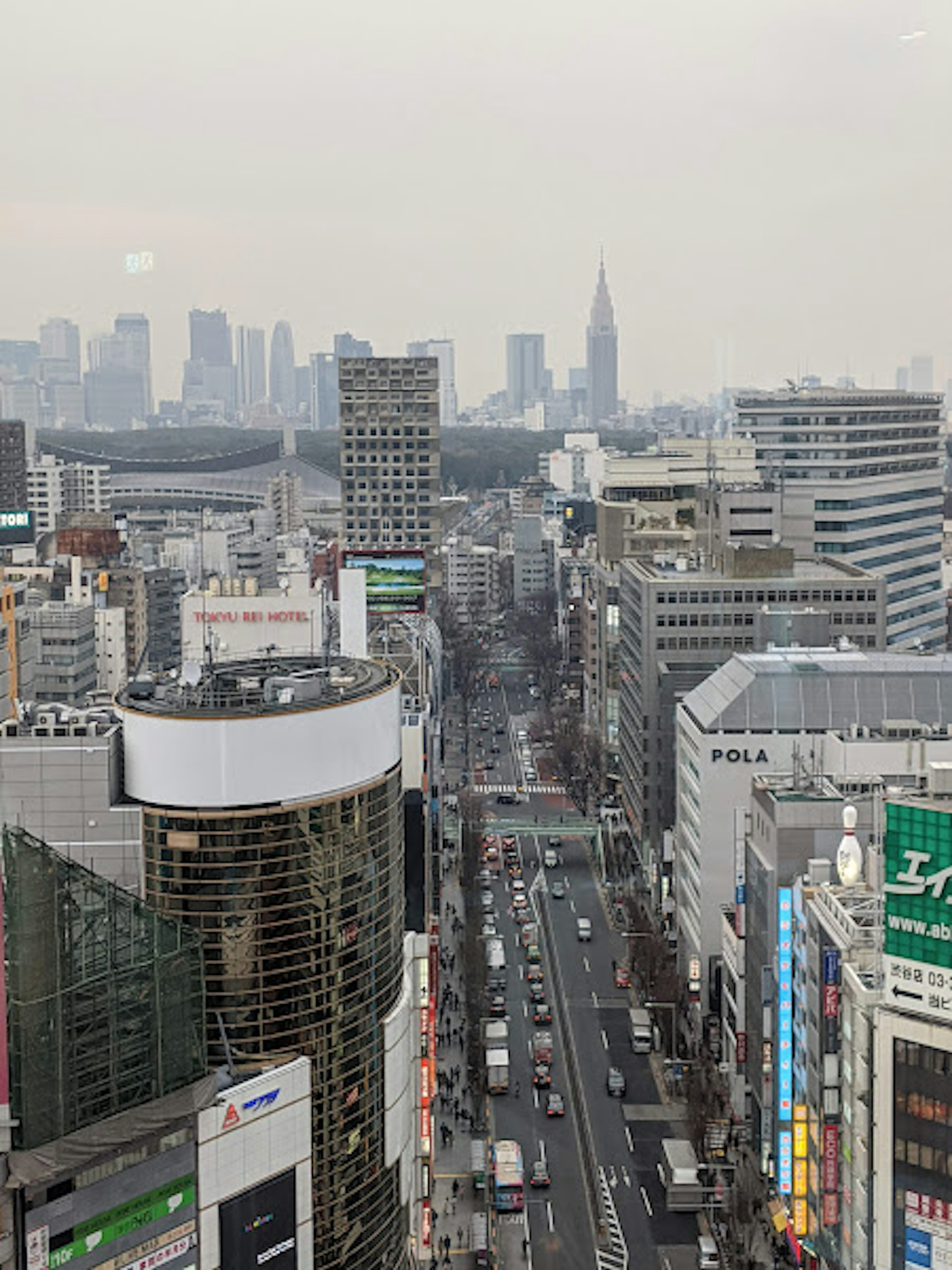 Aerial view of Tokyo's skyscrapers featuring a busy street and the distant Tokyo Skytree