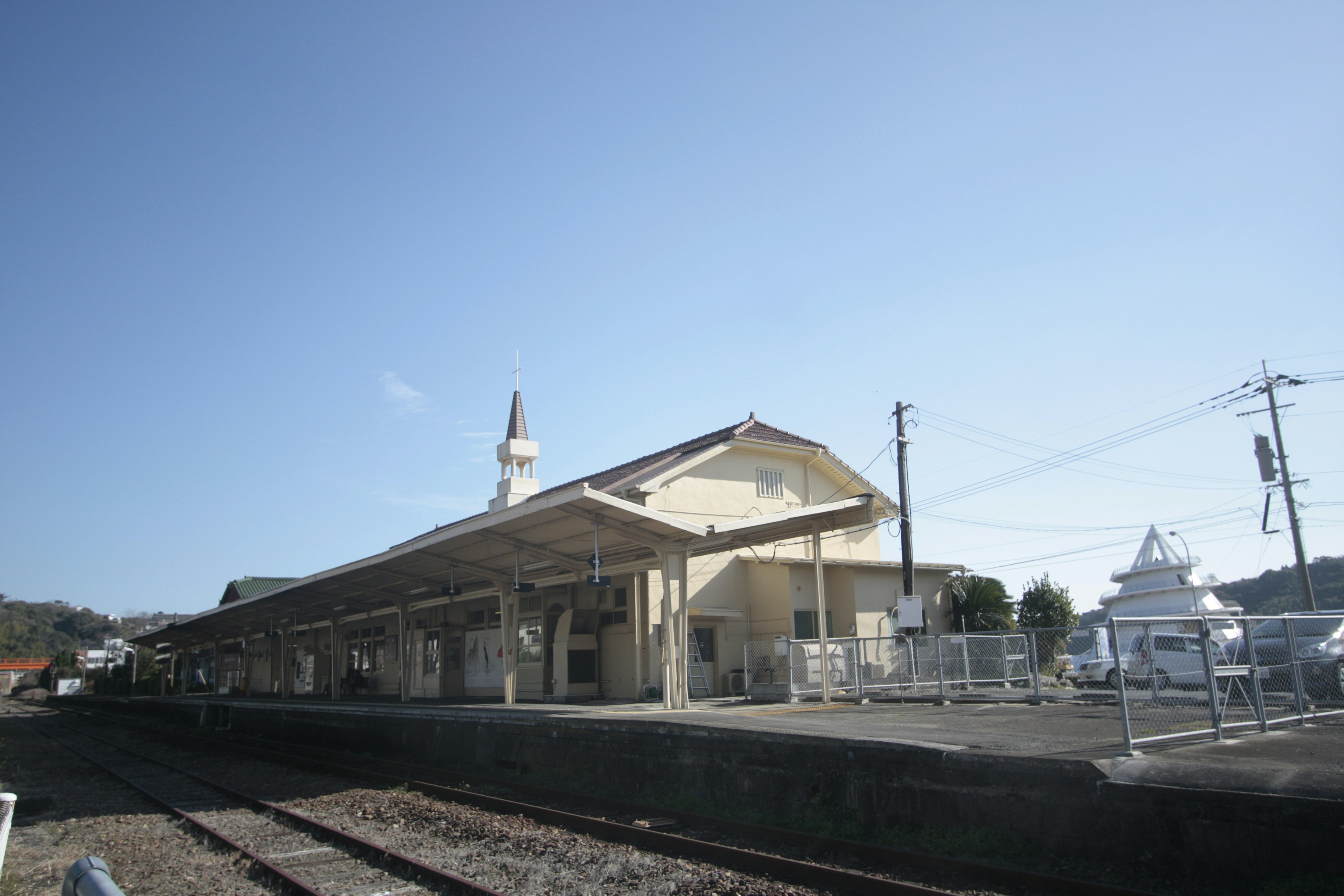 อาคารสถานีรถไฟกับรางรถไฟใต้ท้องฟ้าสีฟ้า