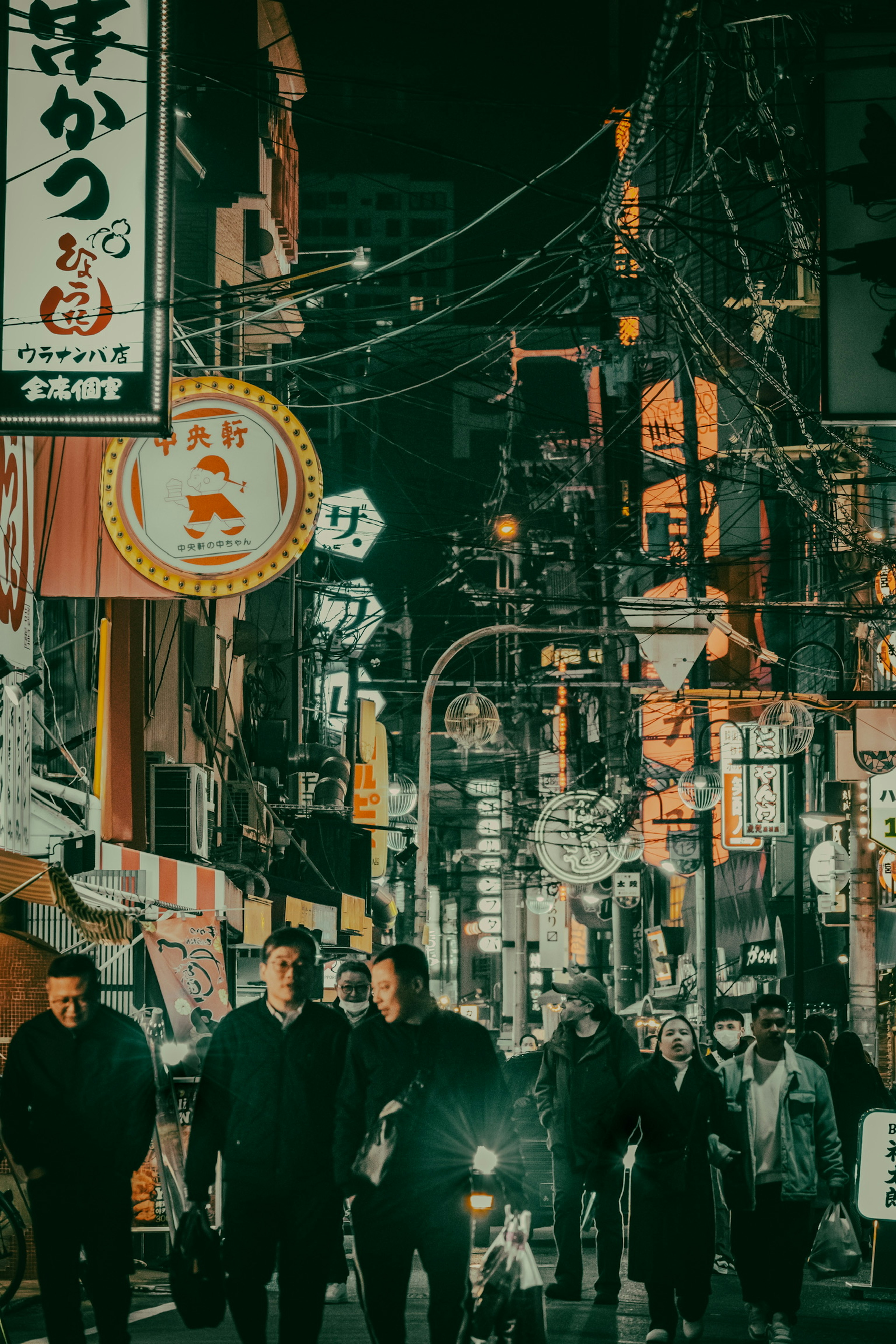 People walking in a vibrant nightlife scene with neon signs