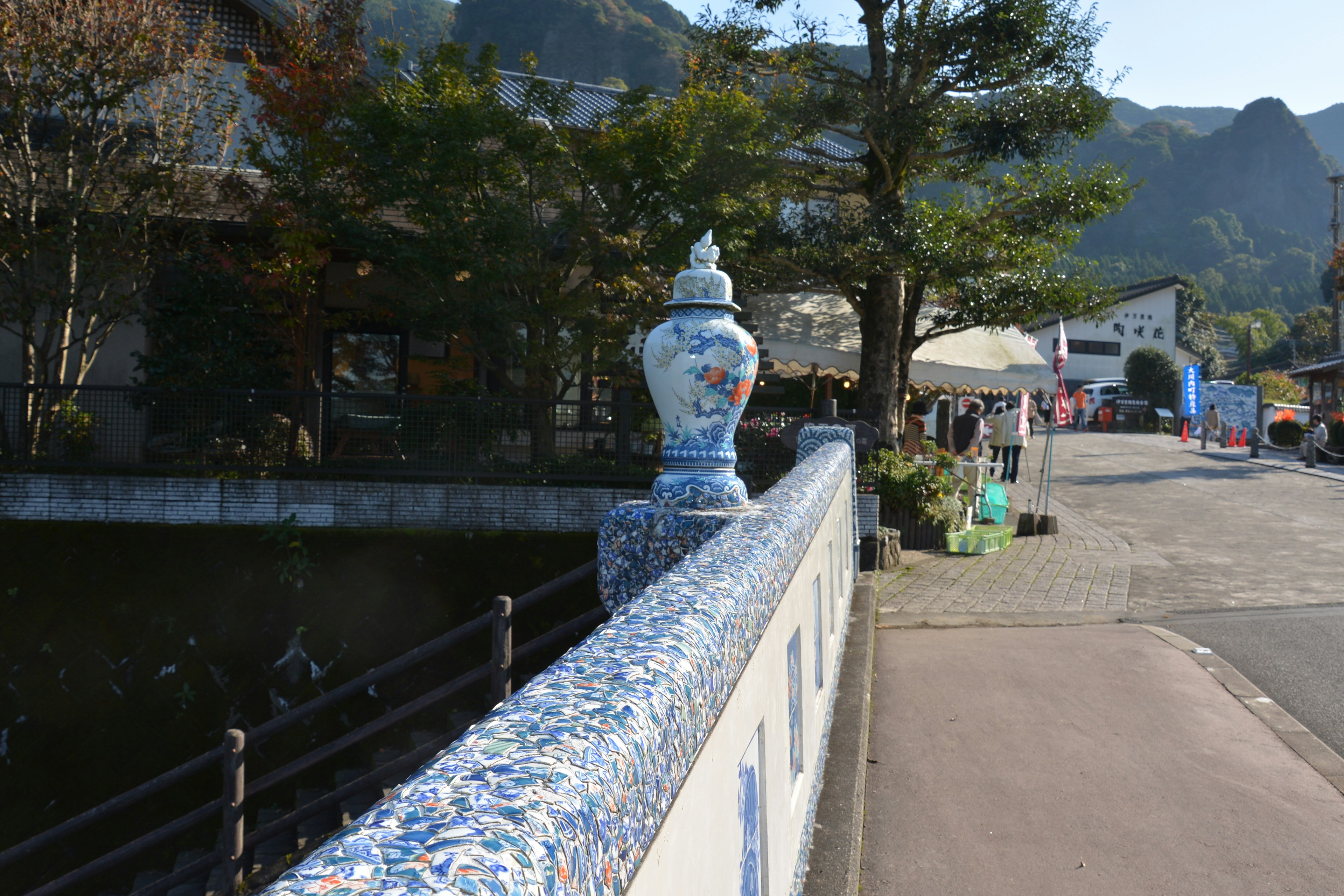 Rambarde de pont décorée de carreaux bleus avec vue sur des bâtiments et des montagnes