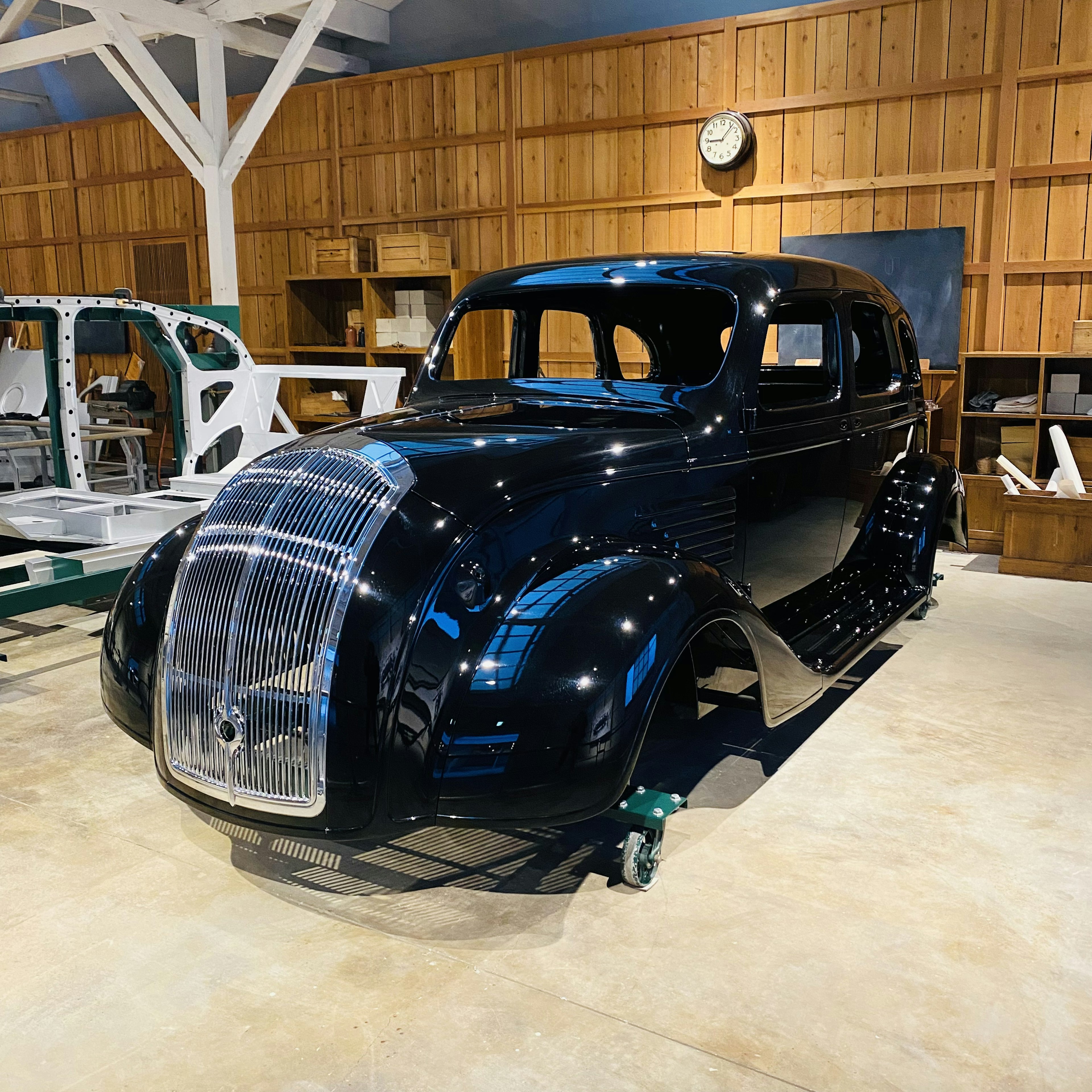 Une voiture classique noire exposée dans un atelier