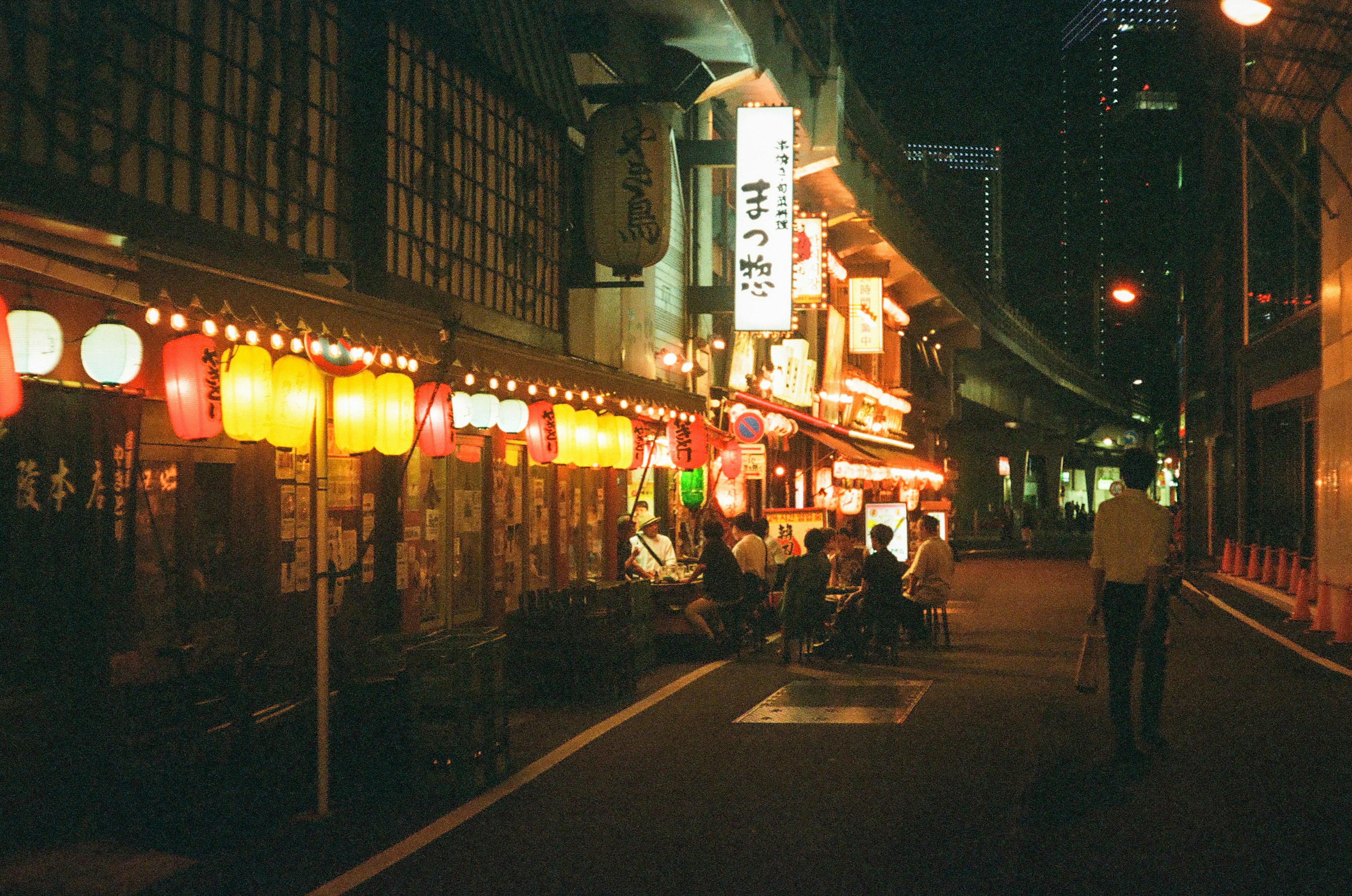 夜の街並みに並ぶ提灯と店舗の光が印象的な通り