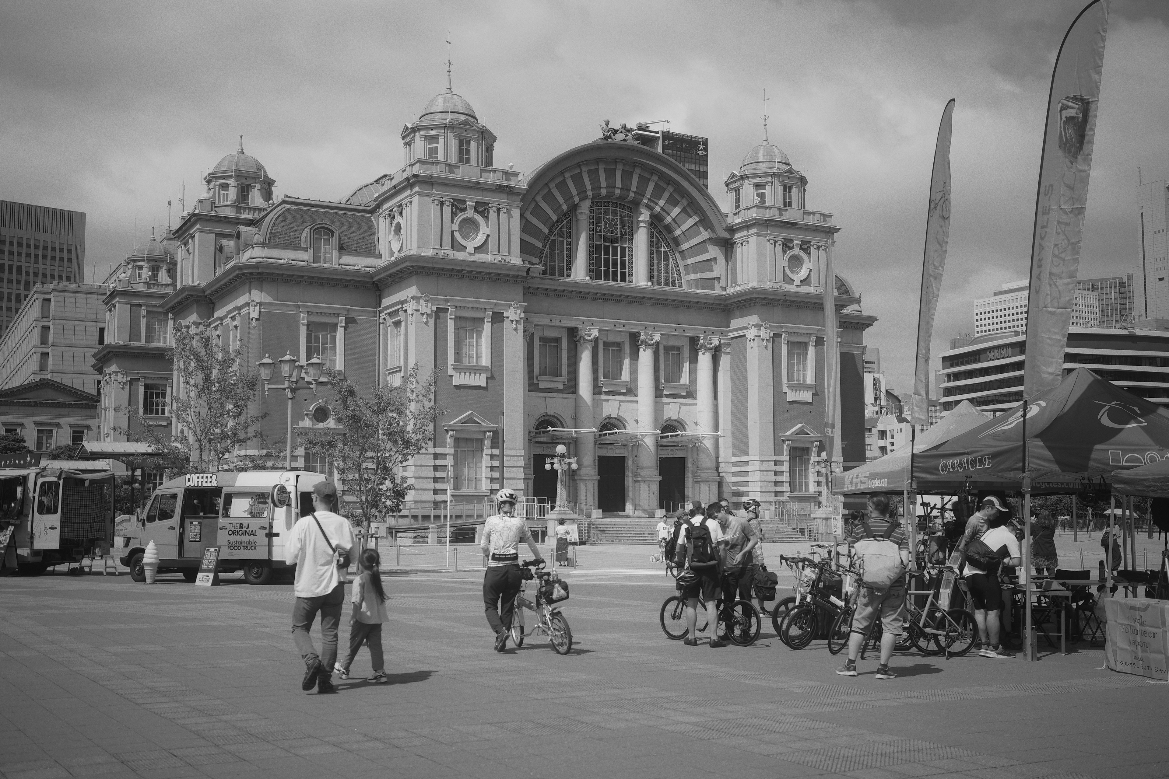 Image en noir et blanc d'un bâtiment historique avec des gens dans une place animée