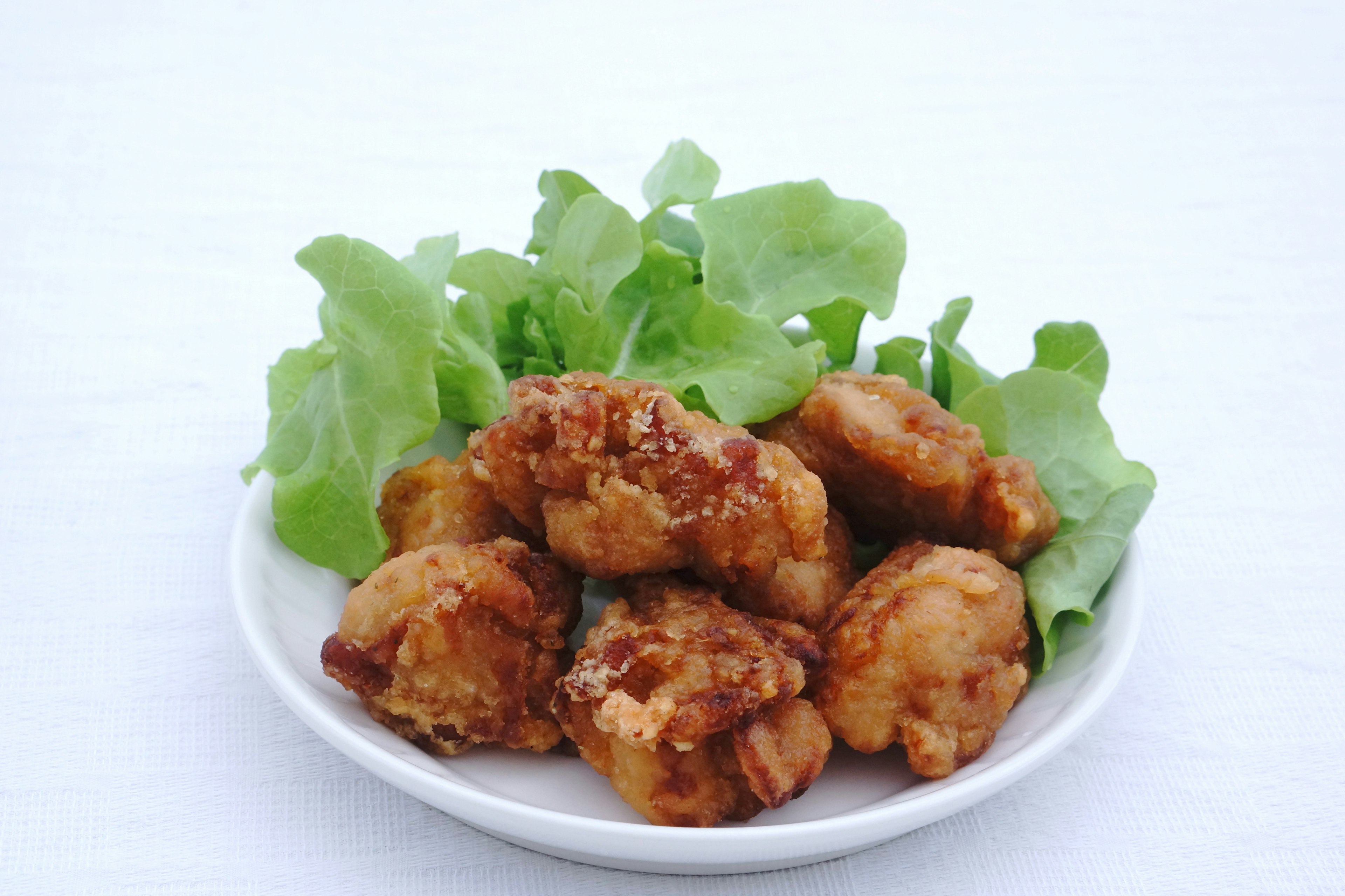 Plate of fried chicken pieces served with lettuce