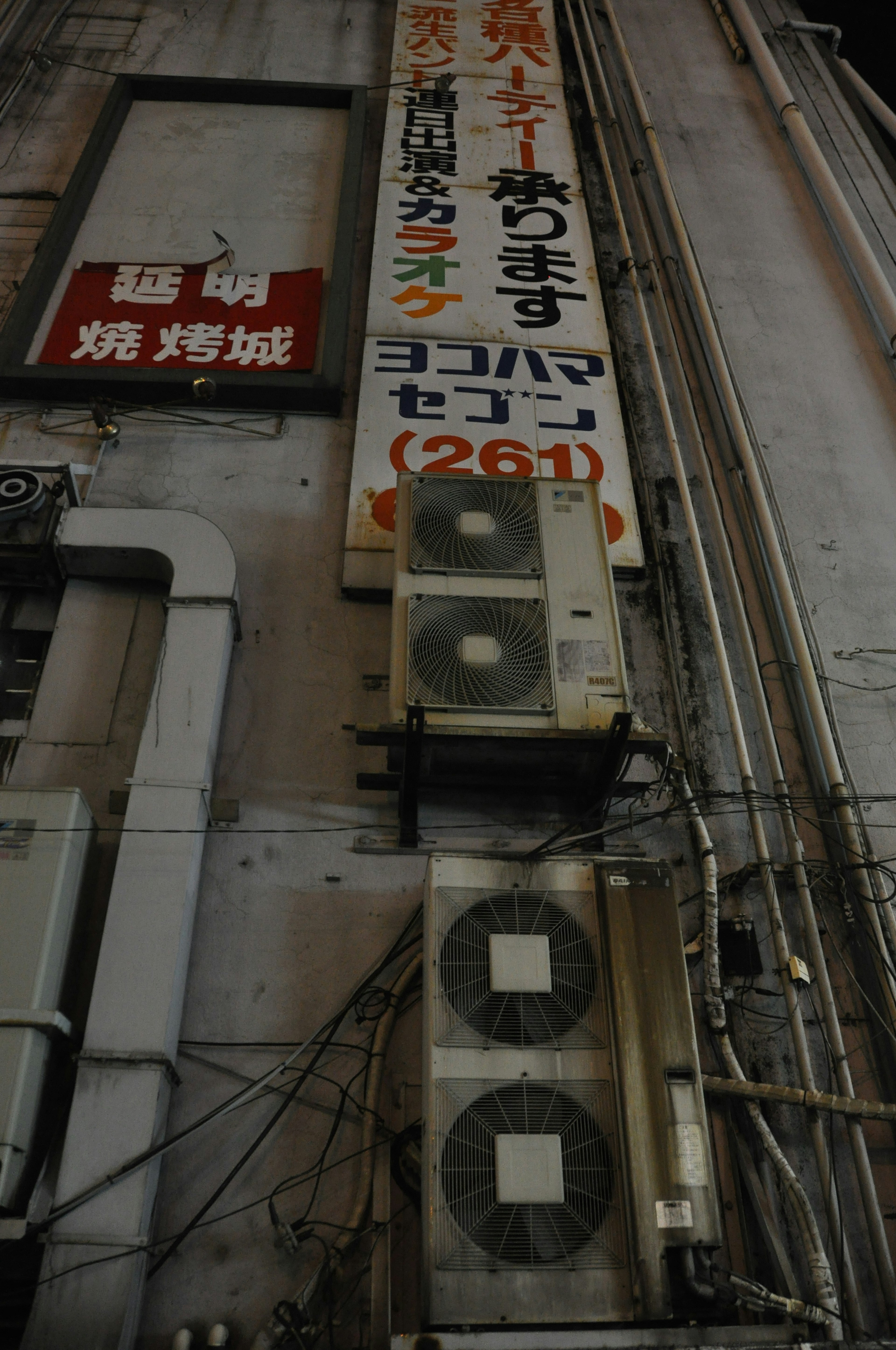 Air conditioning units mounted on a building wall with a sign