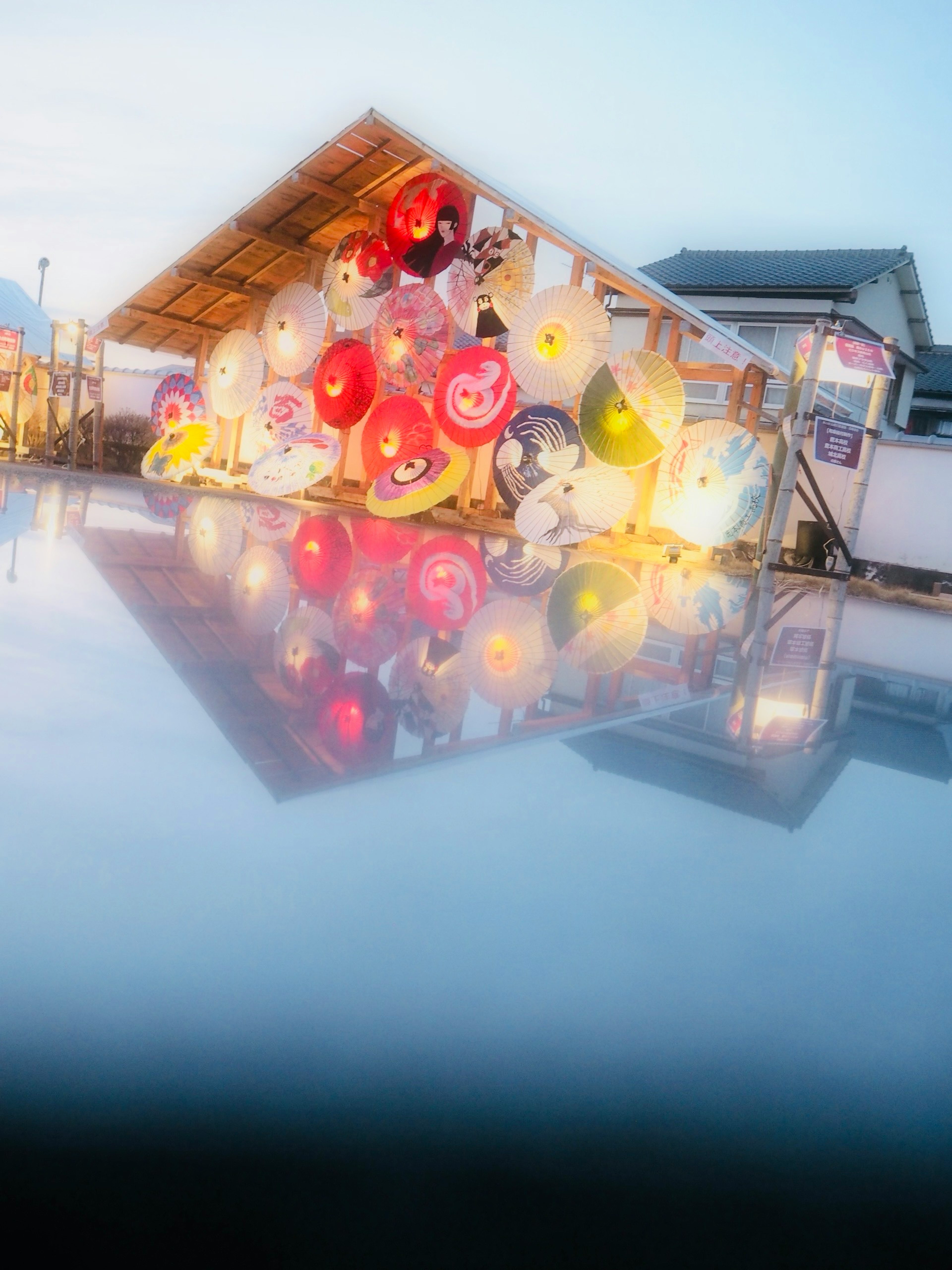 Foto einer farbenfrohen Laternenausstellung, die sich im Wasser spiegelt