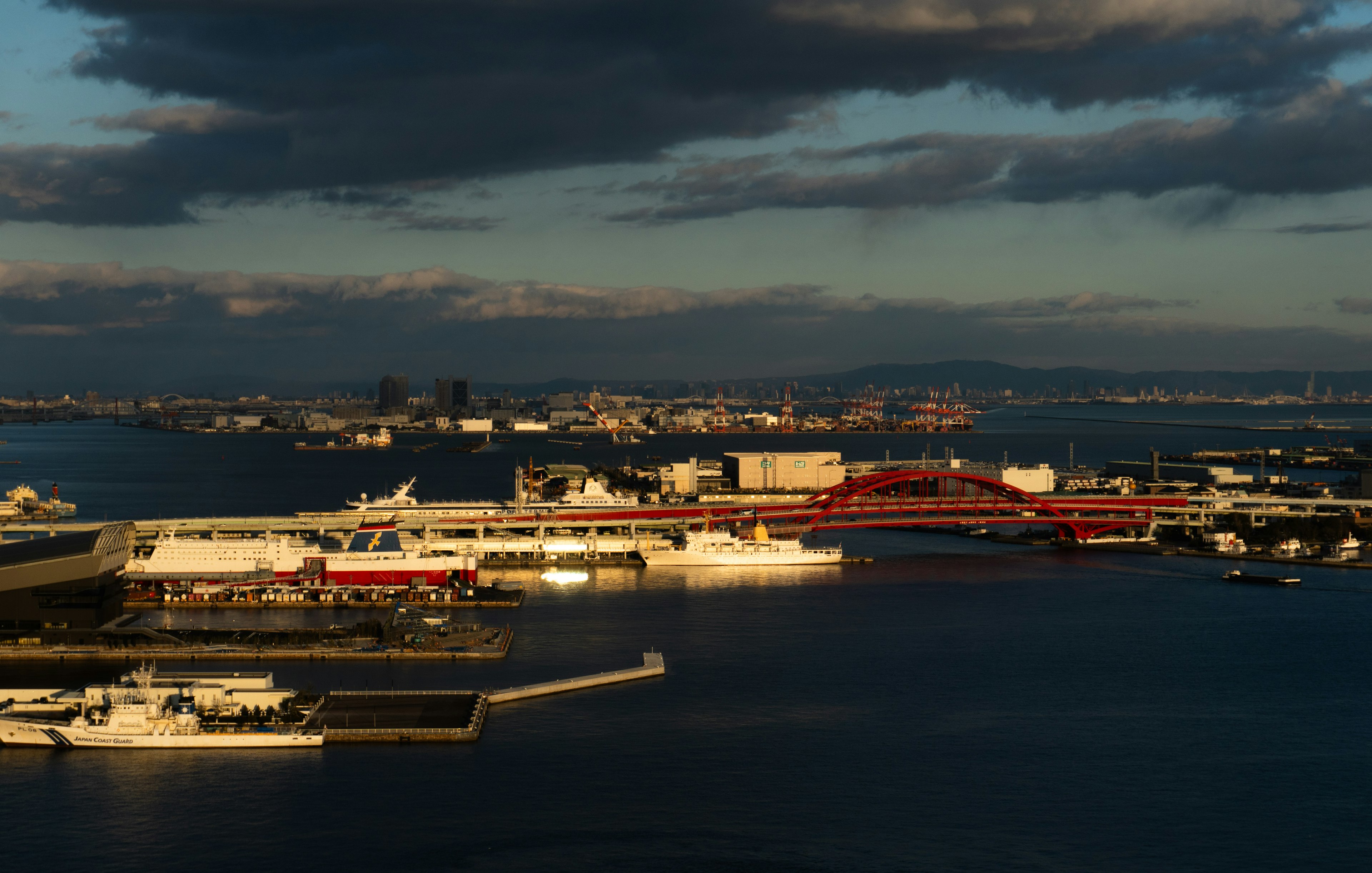 Harbor at dusk showcasing boats and a bridge