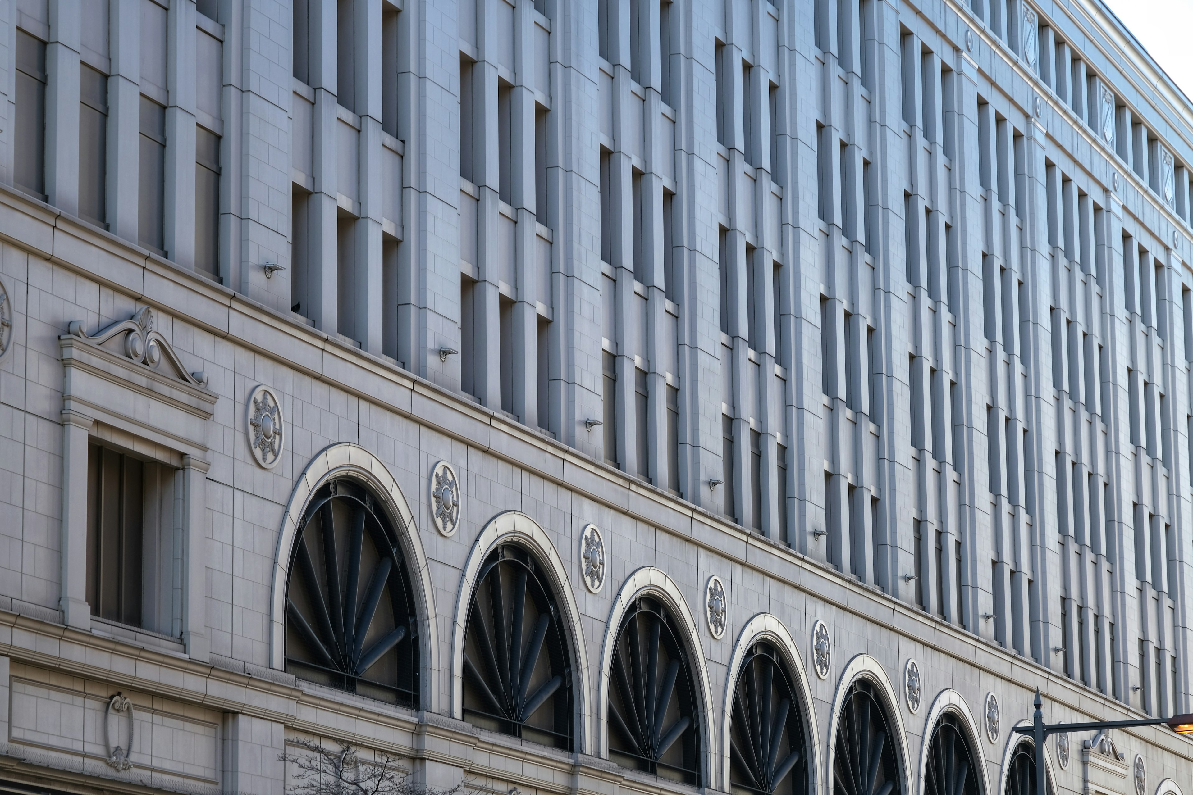 Façade de bâtiment moderne avec design linéaire fenêtres en arc et tons métalliques