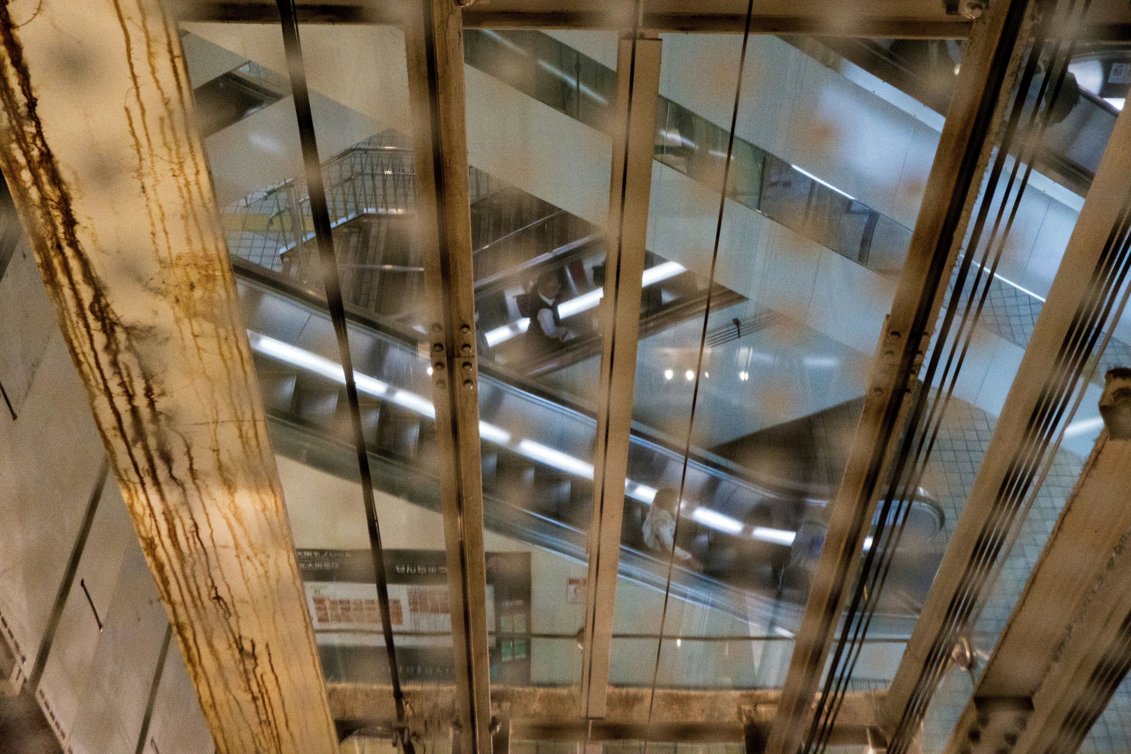 View of an interior structure from above a glass elevator