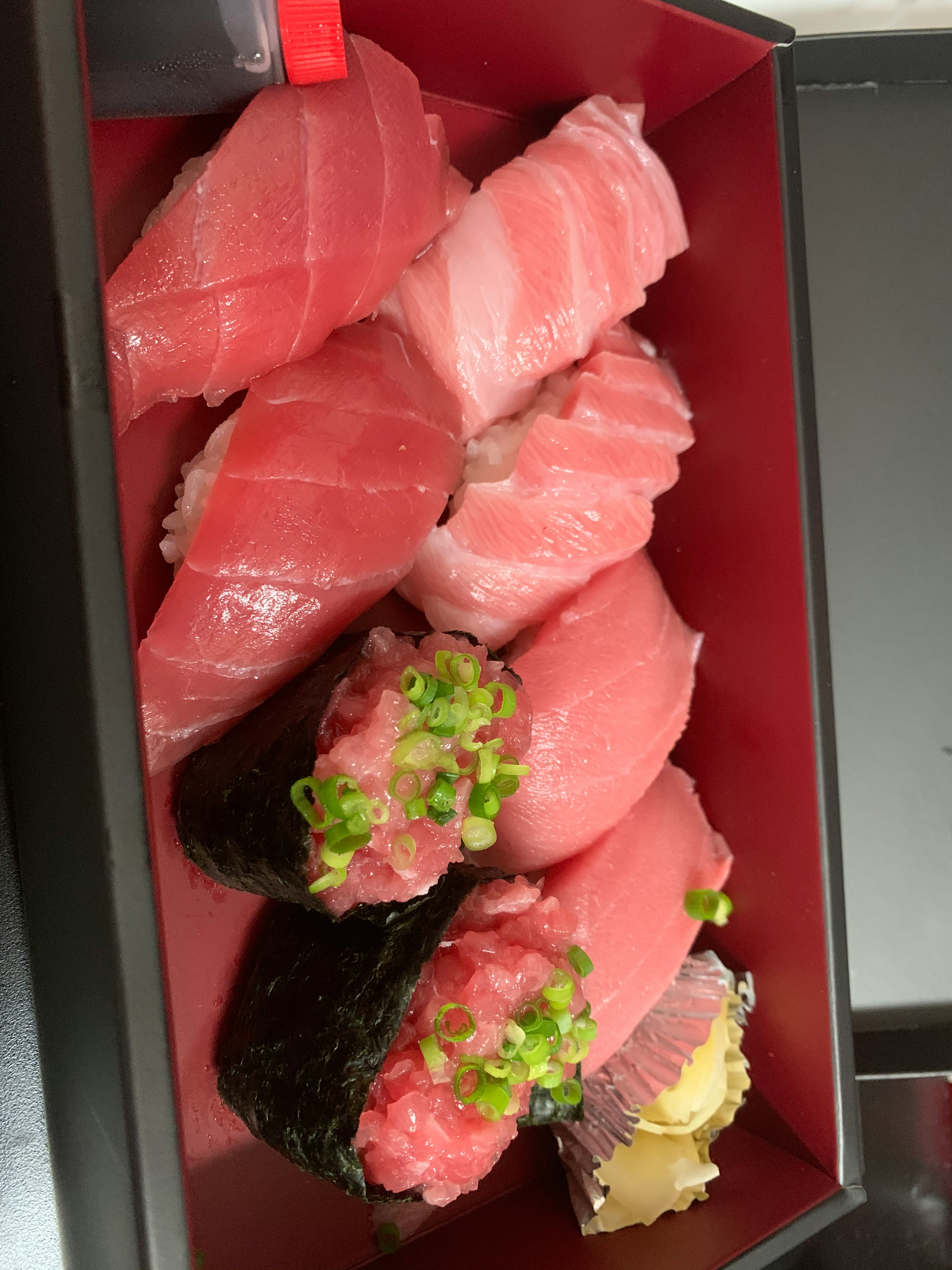 Ein Sortiment frischer Sushi in einer roten Box arrangiert